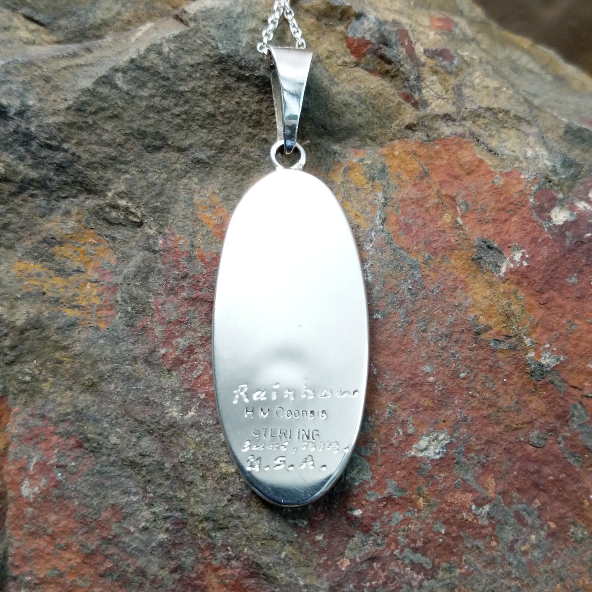 Handcrafted sterling silver Rainbow Kachina pendant by Harlan & Monica Coonsis, featuring vibrant Zuni multistone inlay; artisan and Sterling Silver stamp and engravings.