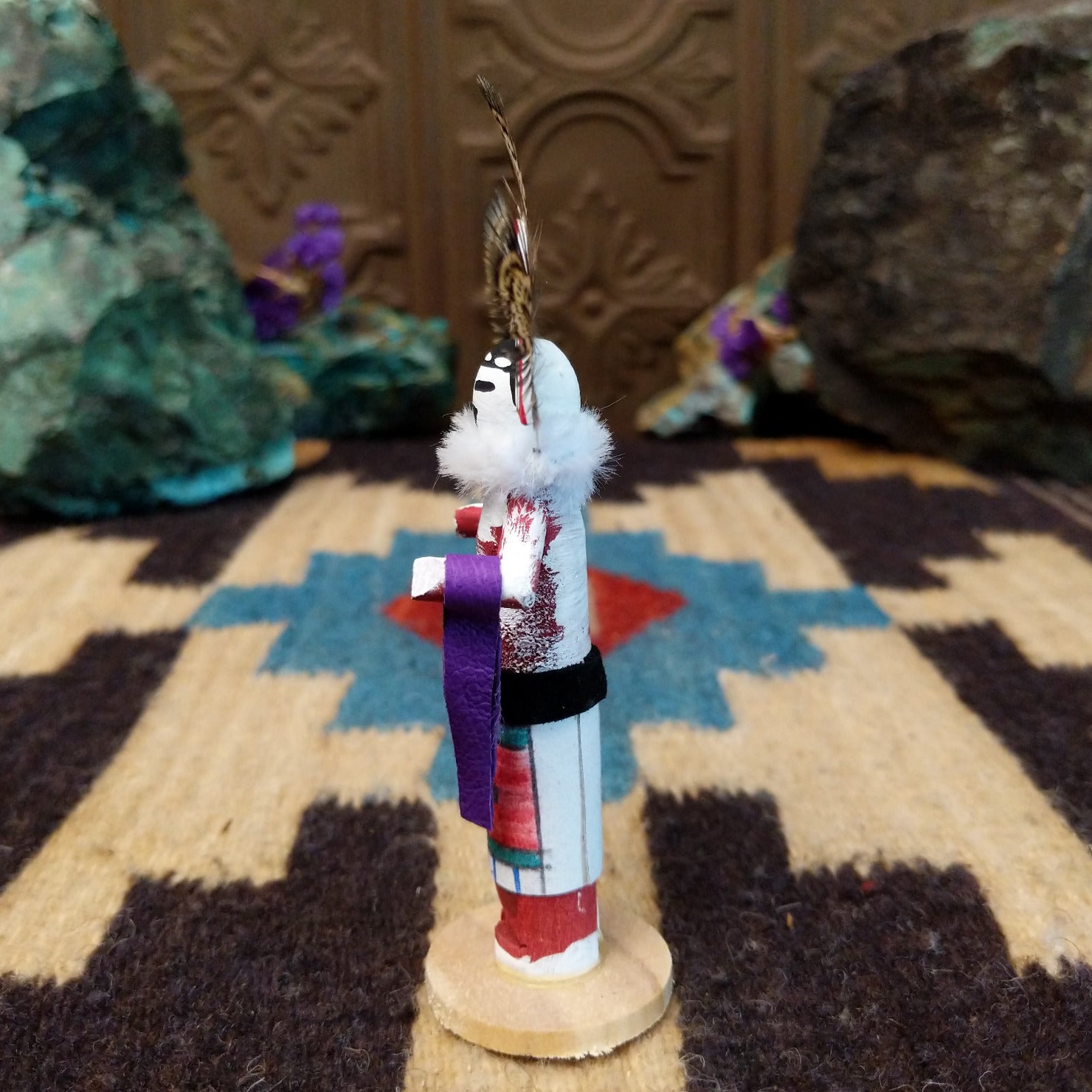 Mini rainbow kachina by Rosalind Grey with multicolored rainbow headdress, patterned feathers, white face, and feather collar.