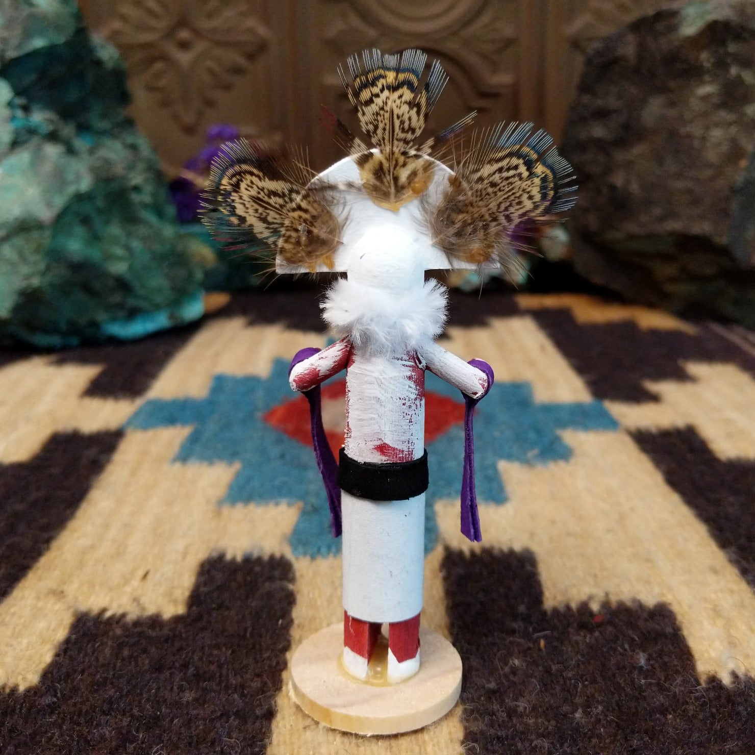 Mini rainbow kachina by Rosalind Grey with multicolored rainbow headdress, patterned feathers, white face, and feather collar.