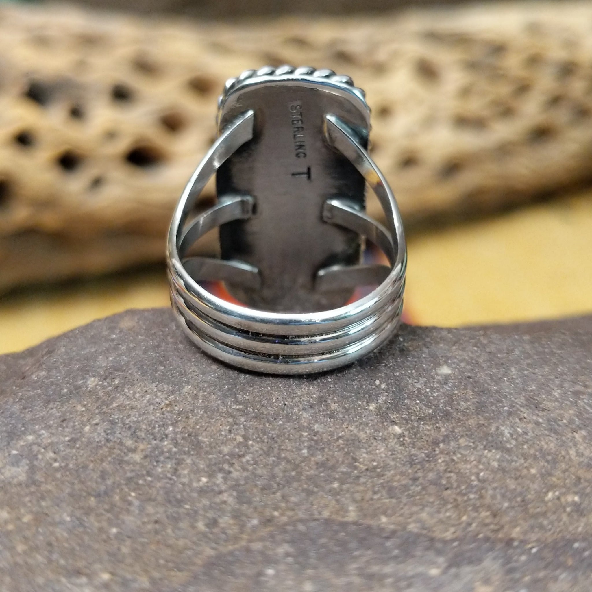 Rectangle bumblebee jasper ring by Terry Wood, featuring a vibrant rectangular bumblebee jasper stone with natural yellow, orange, black, and gray patterns set in a handcrafted sterling silver band. Underside view.