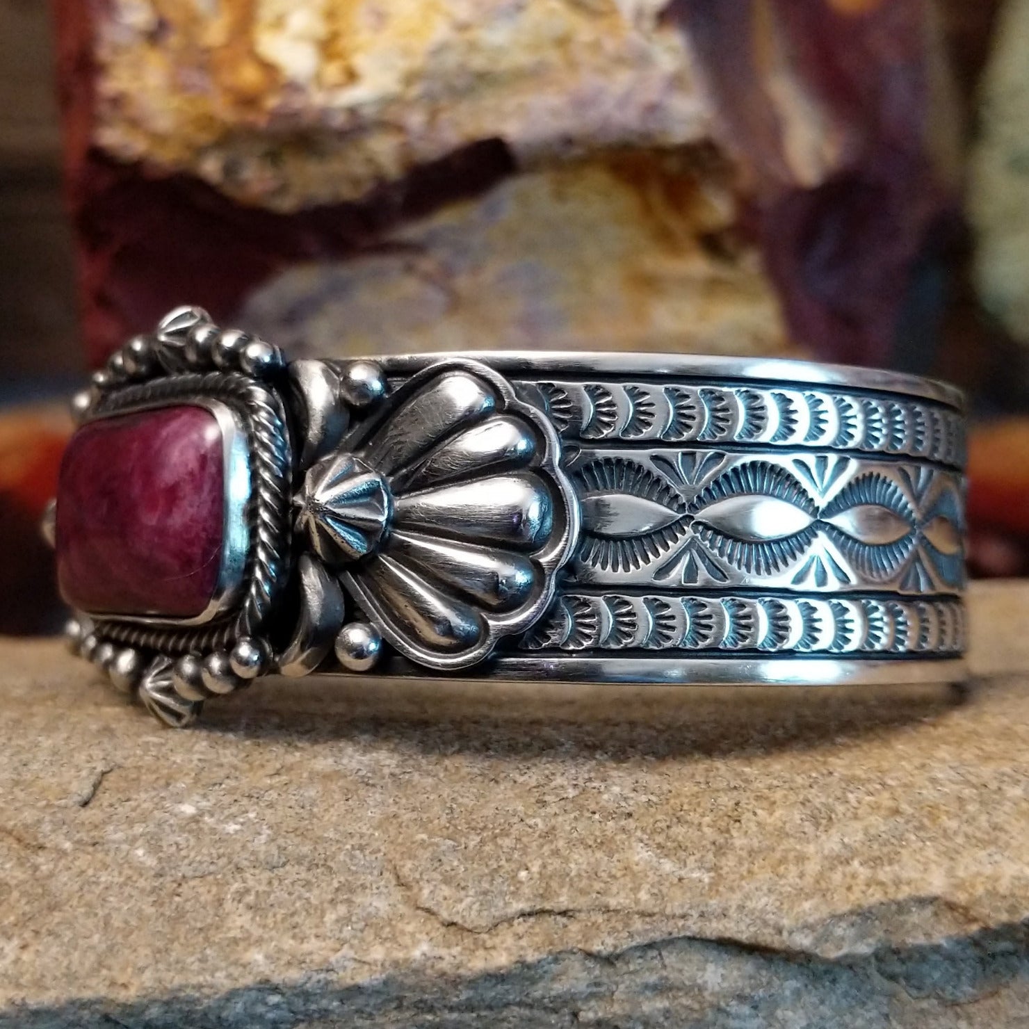 A rectangular purple spiny oyster shell cuff set in detailed sterling silver and ornate band.