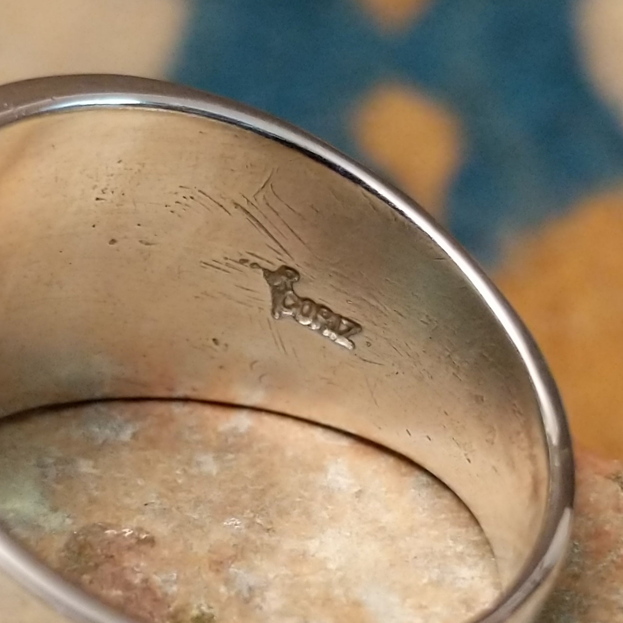 Sterling silver spiral ring by Raymond Coriz featuring a geometric stamped spiral design on a polished signet-style band with Southwestern craftsmanship; artisan stamp.