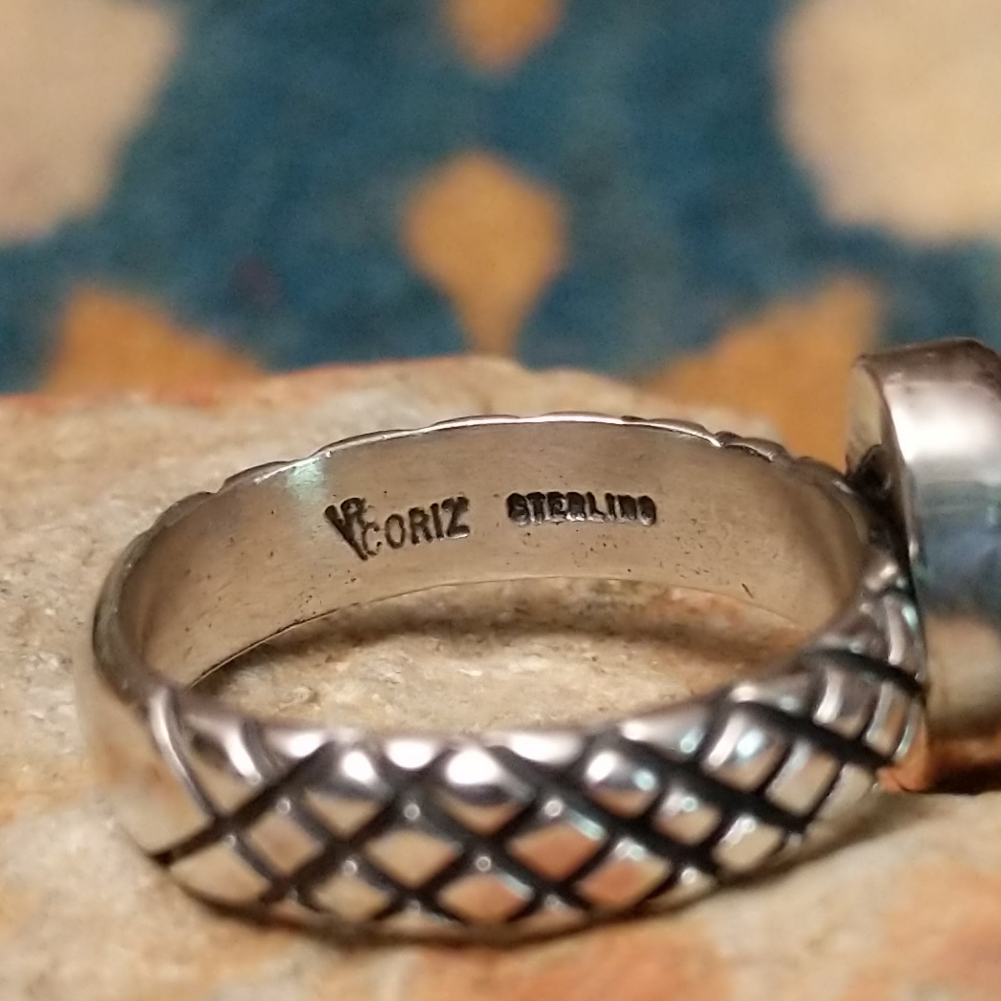 Sterling silver Red Spiny Oyster Shell ring by Raymond Coriz with a hand-stamped band and oval red gemstone; artisan and Sterling Silver stamp.