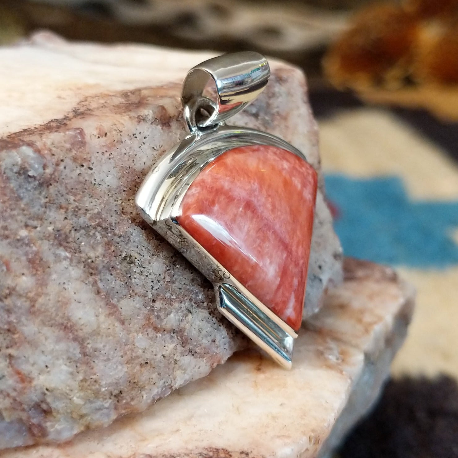 Sterling silver quarter circle pendant with red spiny oyster shell set in the bezel.