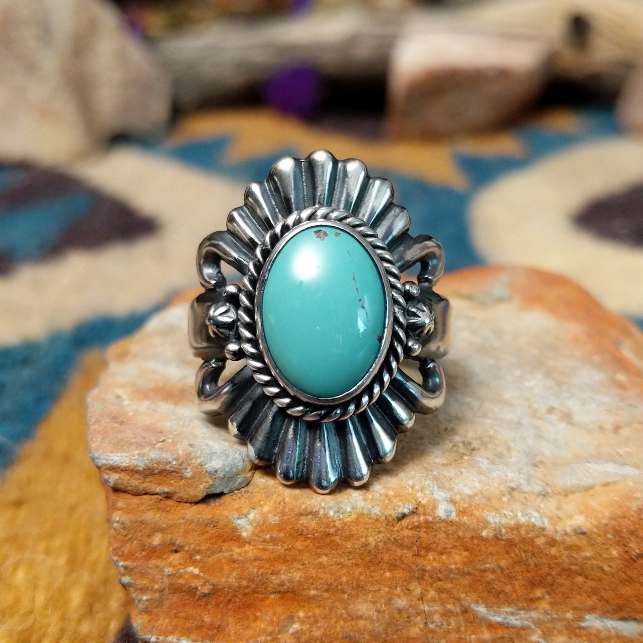 Sterling silver turquoise ring by Raymond Coriz featuring an oval turquoise cabochon, twisted rope bezel, concho-inspired fan design, and intricate Southwestern silverwork.