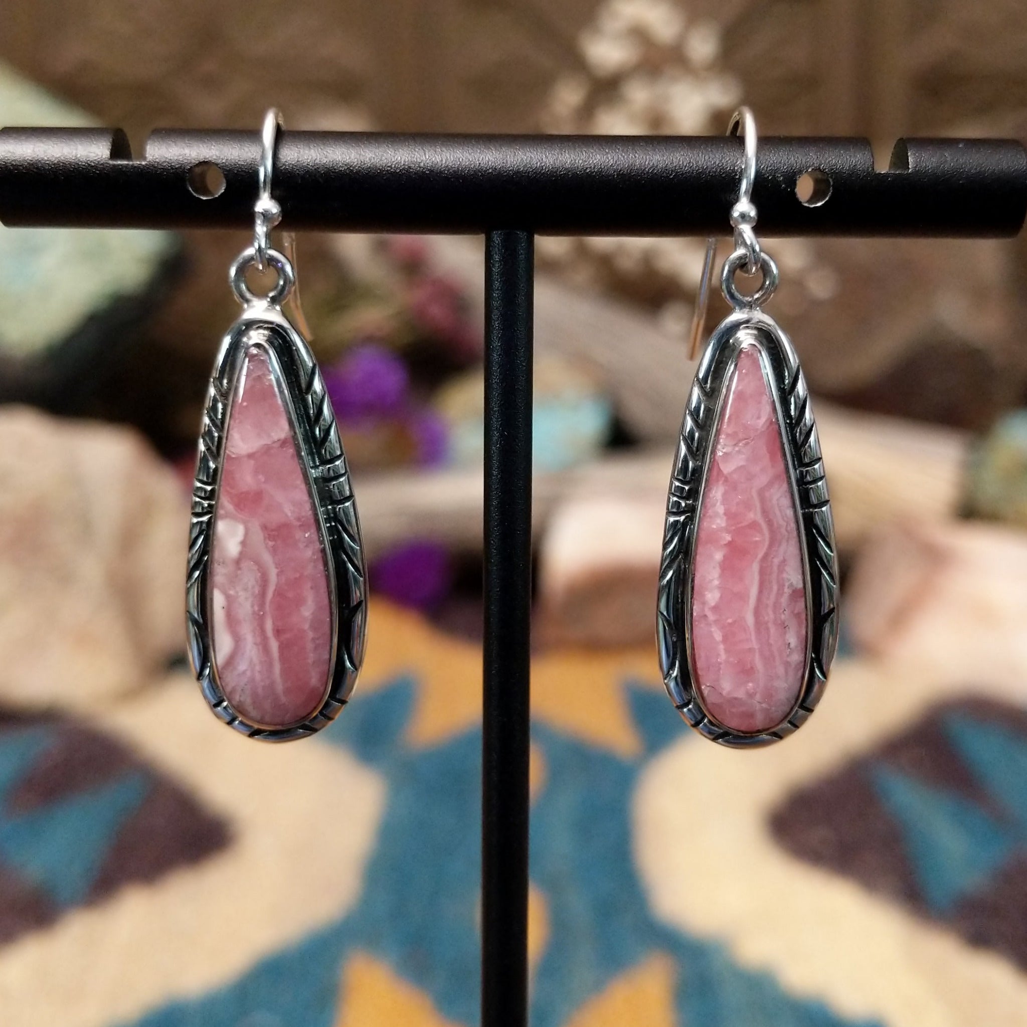 Handcrafted sterling silver teardrop earrings by John King featuring natural rhodochrosite with soft pink and white banding in hand-stamped sterling silver settings on French hooks.