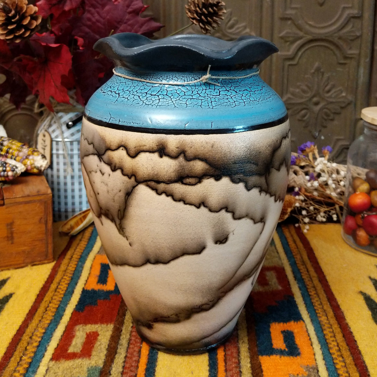 Horsehair pottery vase by Roger Calhoun with a rippled dark rim, metallic blue crackled upper section, and branching black horsehair patterns across a cream-colored body.
