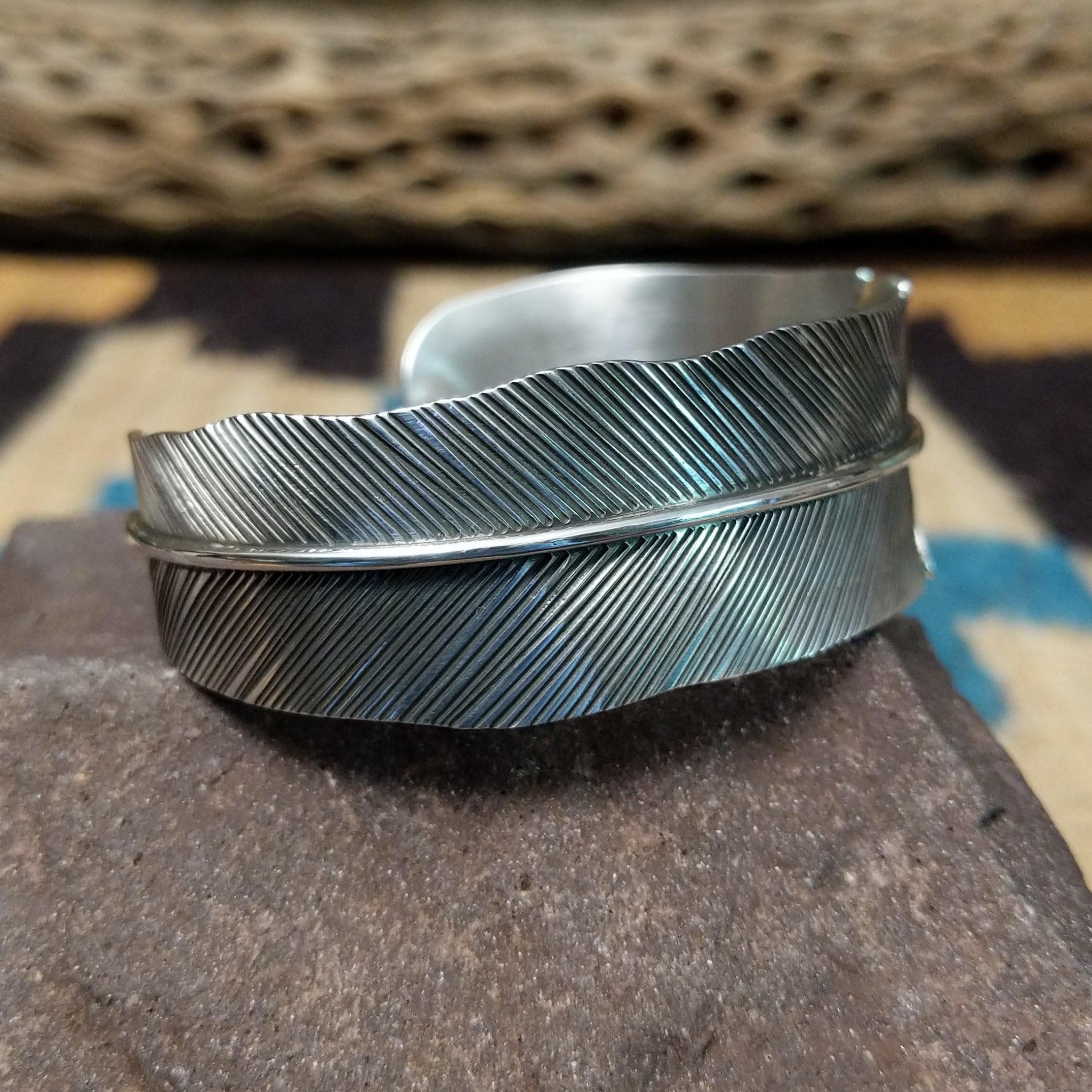 Rippling silver feather cuff by Terry Wood, featuring a handcrafted sterling silver feather design with flowing engraved details and traditional Southwestern-inspired craftsmanship.