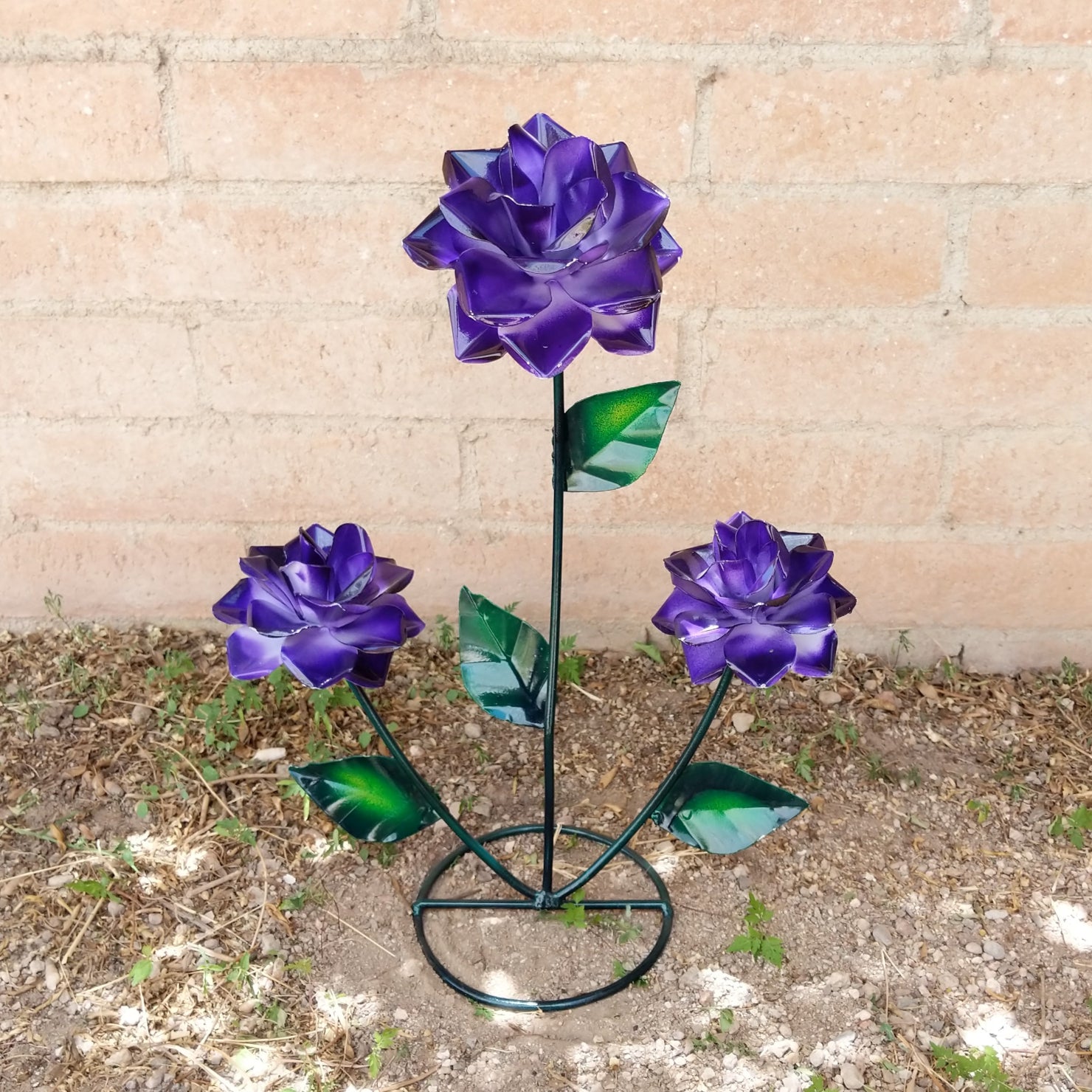 A purple rose bouquet metal art piece with three rich purple roses and green leaves.