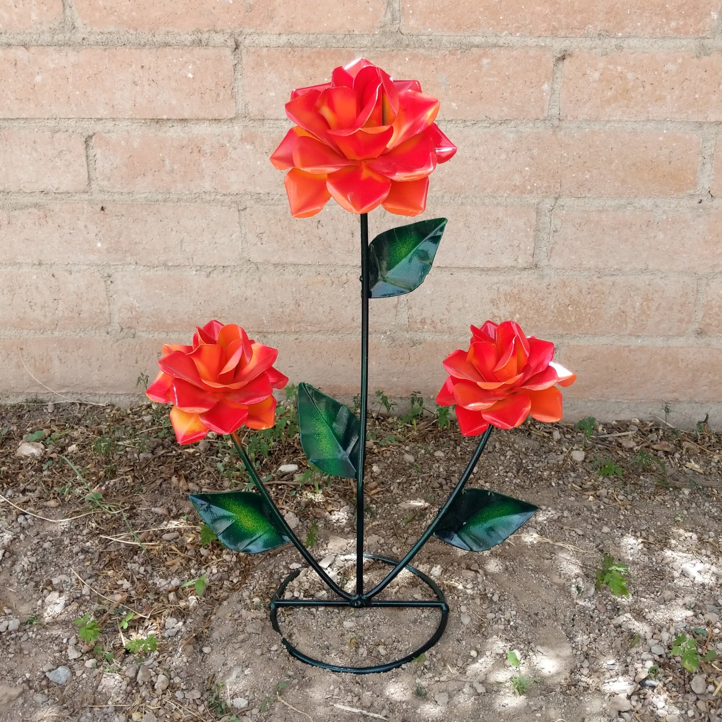 An orange rose bouquet metal art piece featuring three vibrant roses with green leaves.