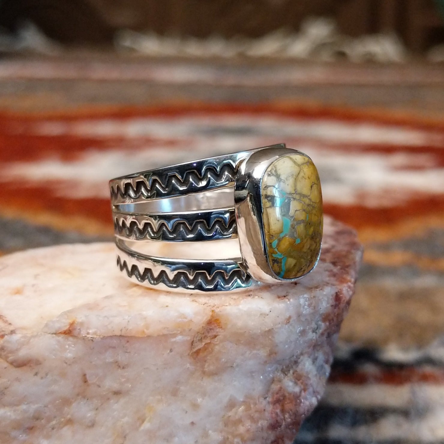 Rectangular boulder turquoise set within the bezel of the ring.