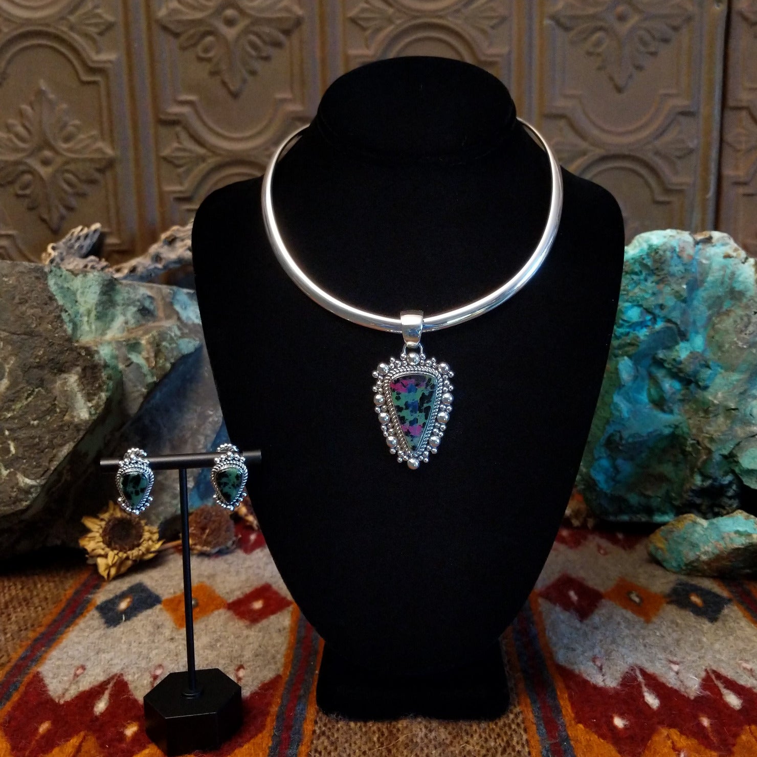 Ruby zoisite set in sterling silver bezels framed by dotted accents on both the earrings and pendant.