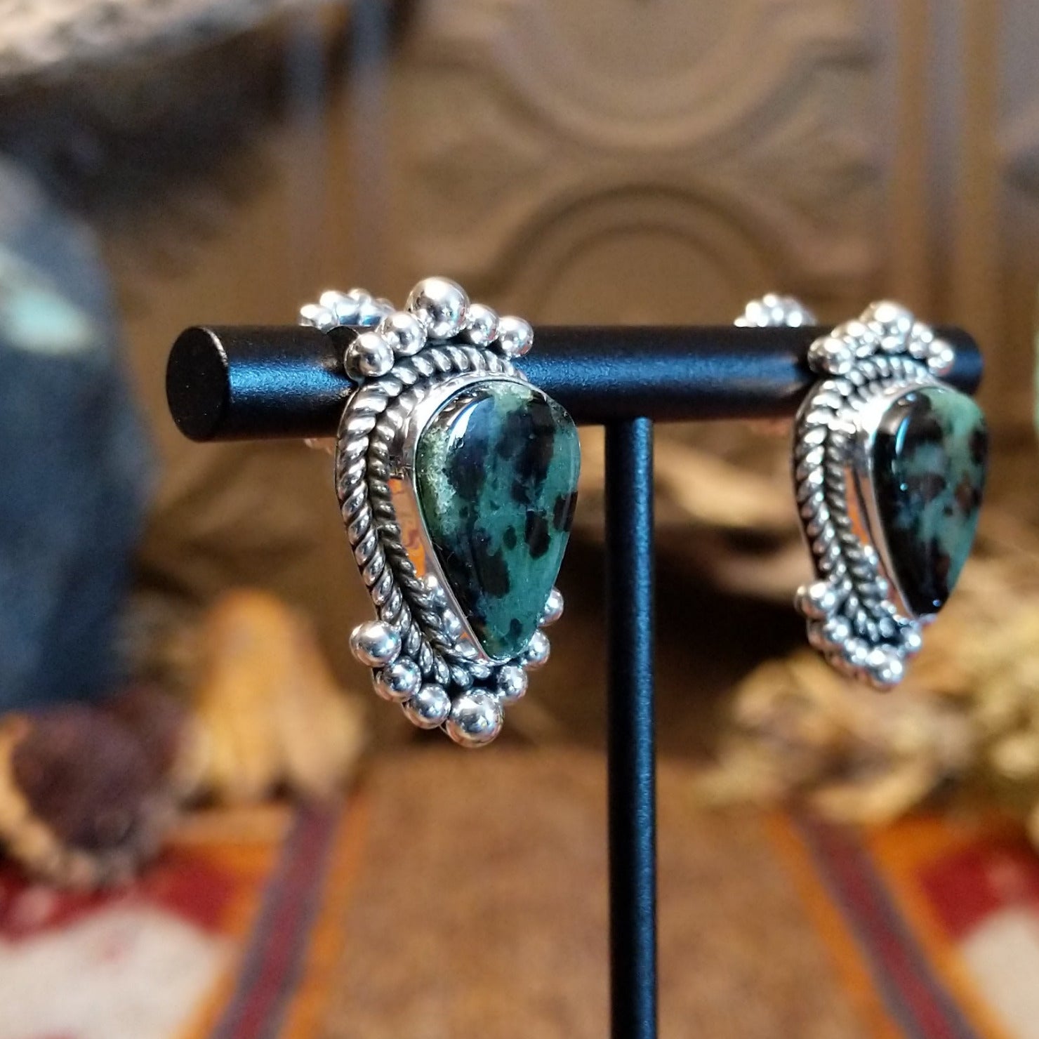 Ruby zoisite set in sterling silver bezels framed by dotted accents on both the earrings and pendant.