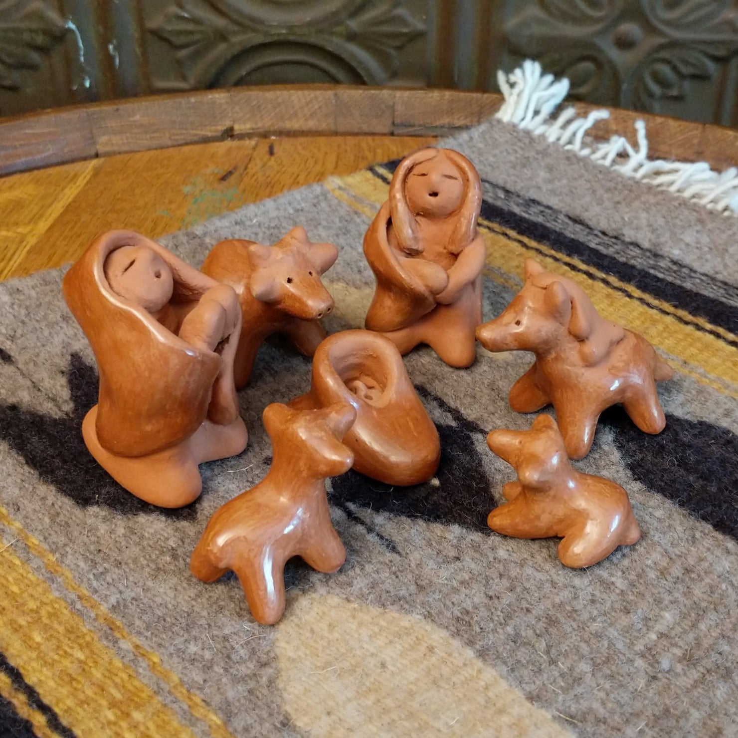 Clay sculpted into individual pieces of a nativity scene and glazed.
