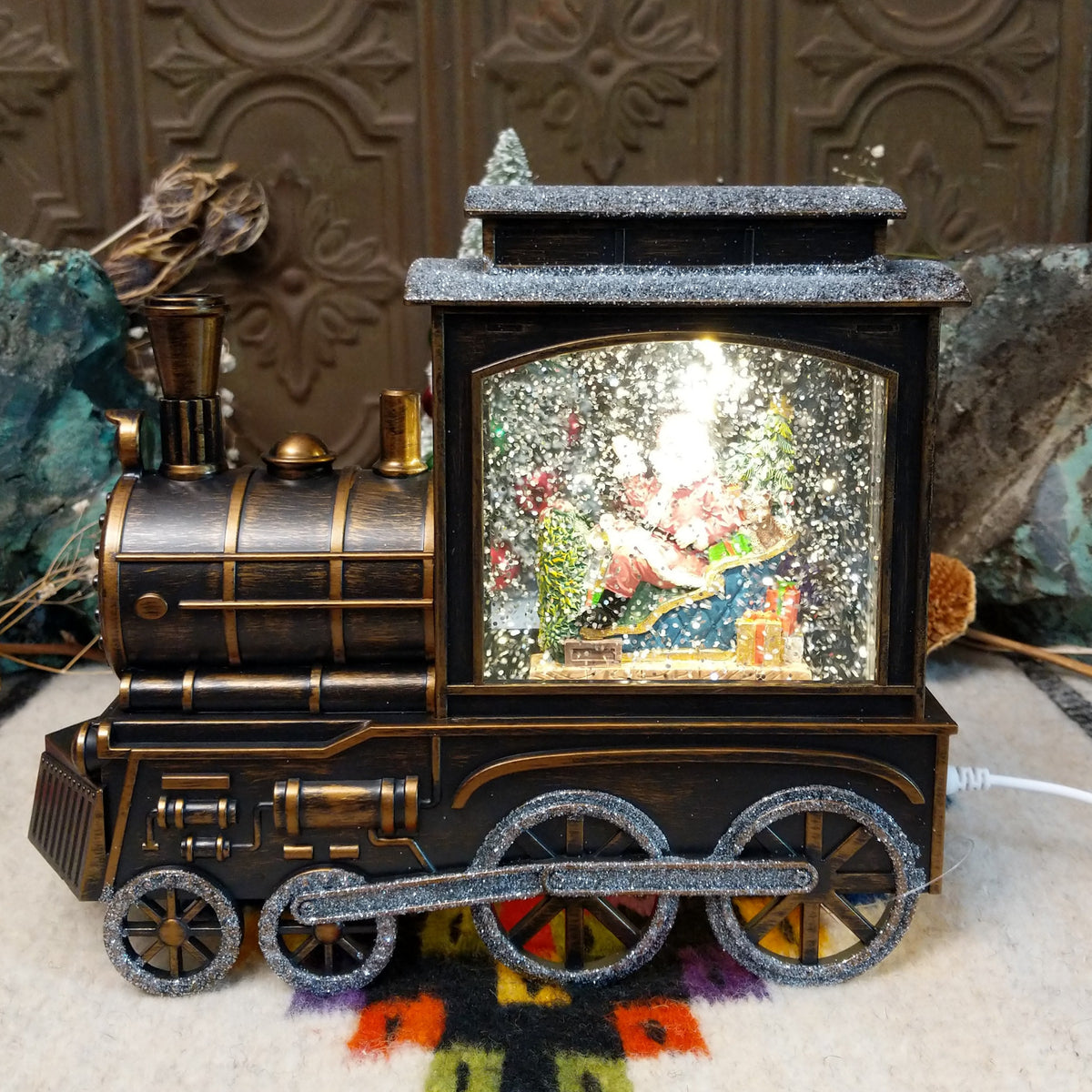 Vintage steam train snow globe with Santa in a sleigh, Christmas trees, presents, teddy bear, lights, and swirling glitter snow.