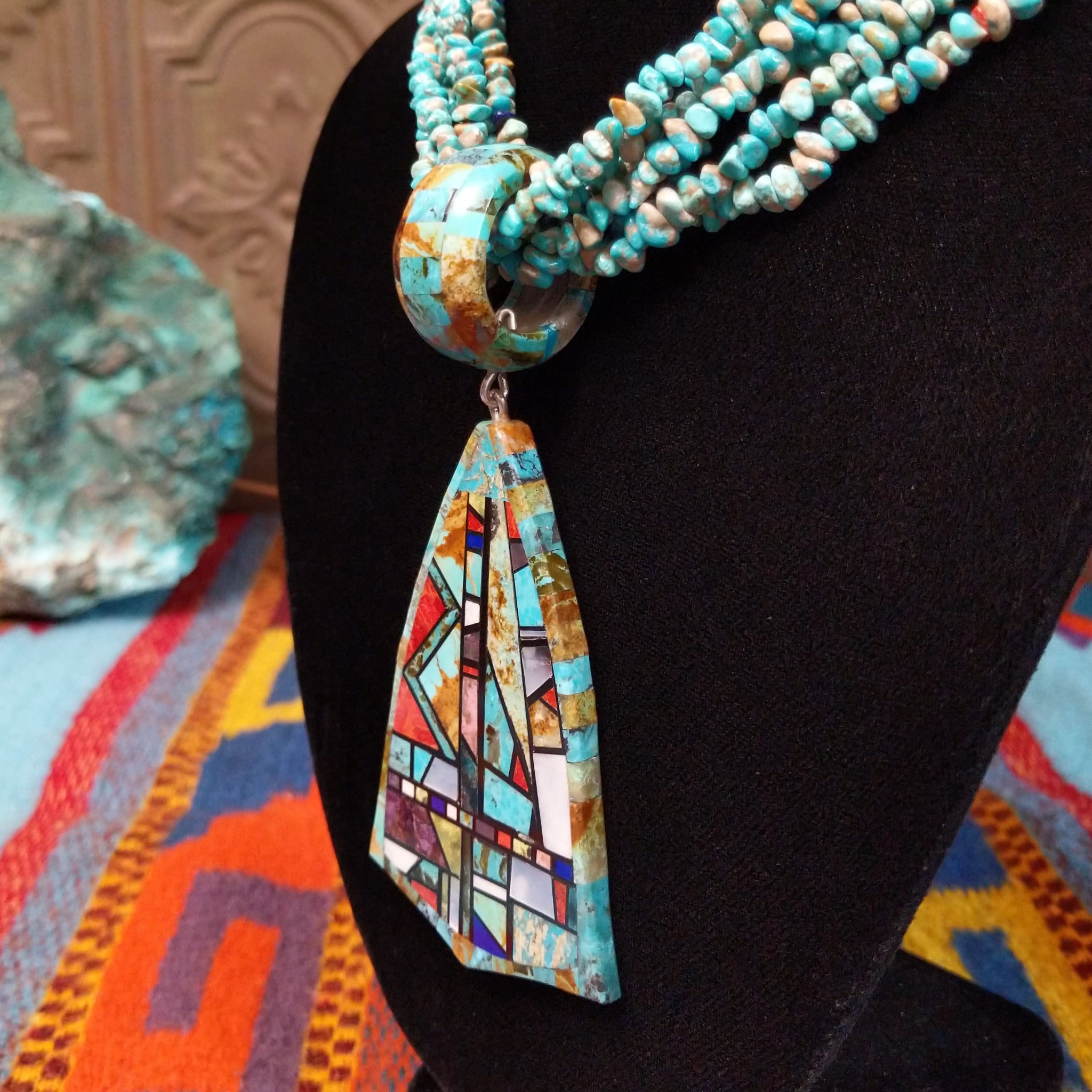 Multi-strand turquoise bead necklace with a large geometric multistone mosaic pendant