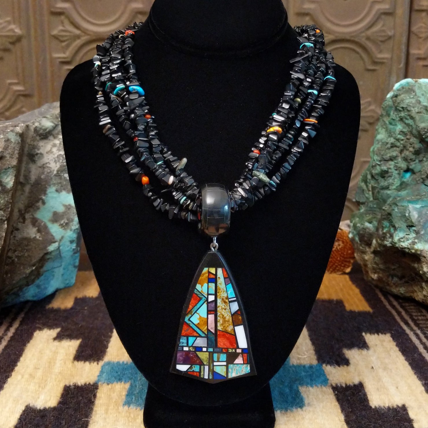 Sterling silver necklace featuring beaded strands and multistone inlay on the pendant.