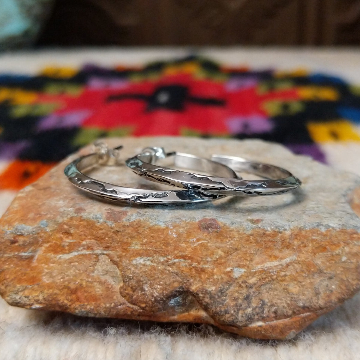 Silver angular hoop earrings by Verna Tahe.