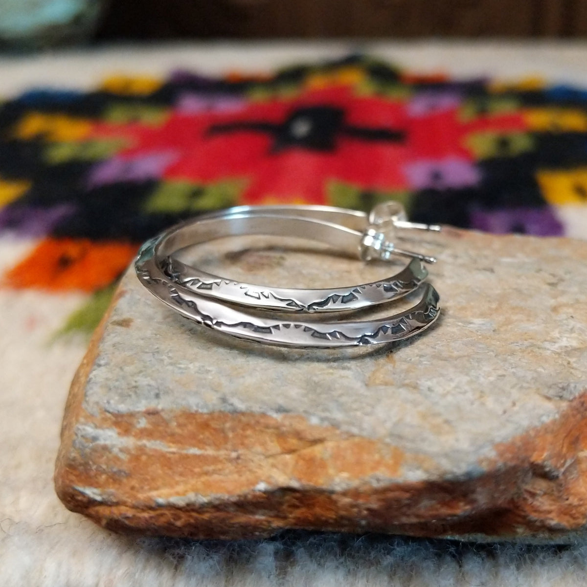 Silver angular hoop earrings by Verna Tahe.