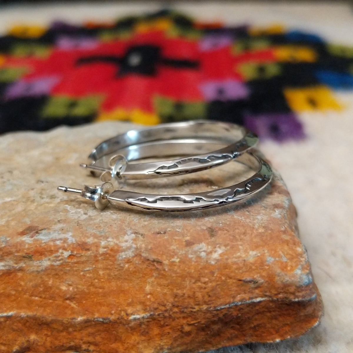 Silver angular hoop earrings by Verna Tahe.