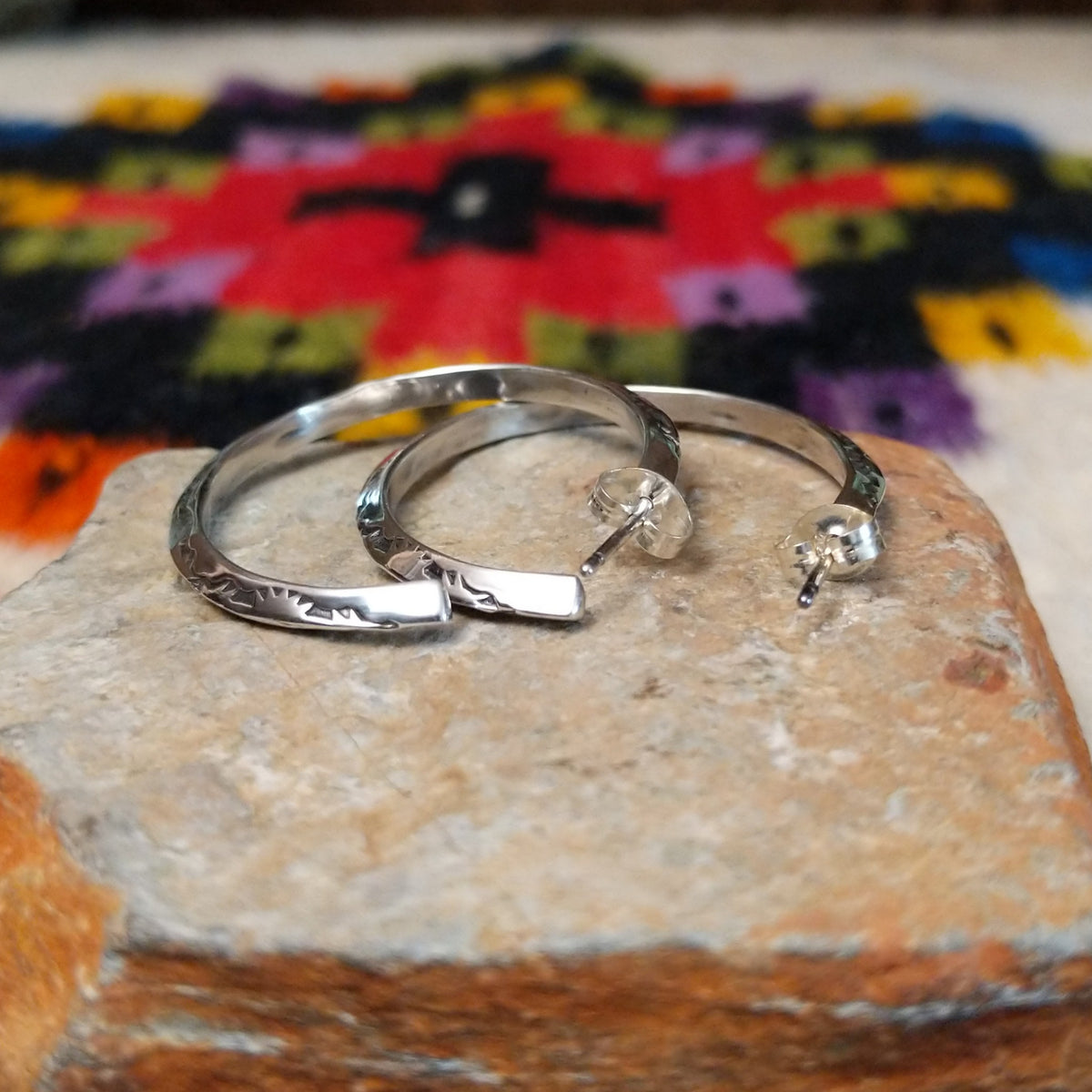 Silver angular hoop earrings by Verna Tahe.
