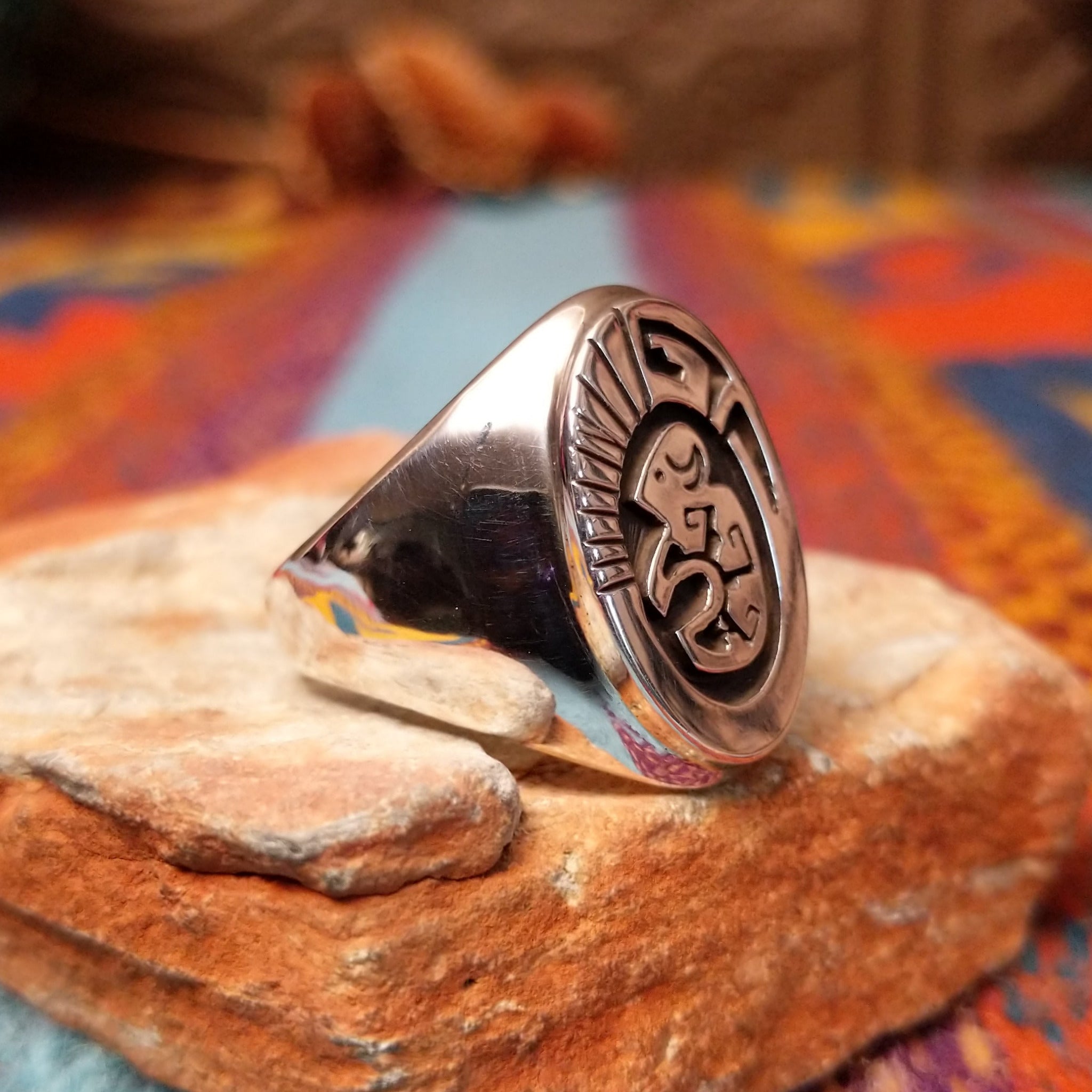 Silver Bison Ring by Calvin Peterson featuring a raised bison motif with geometric detailing, darkened recessed accents, and a polished Sterling Silver oval face and band; side view.