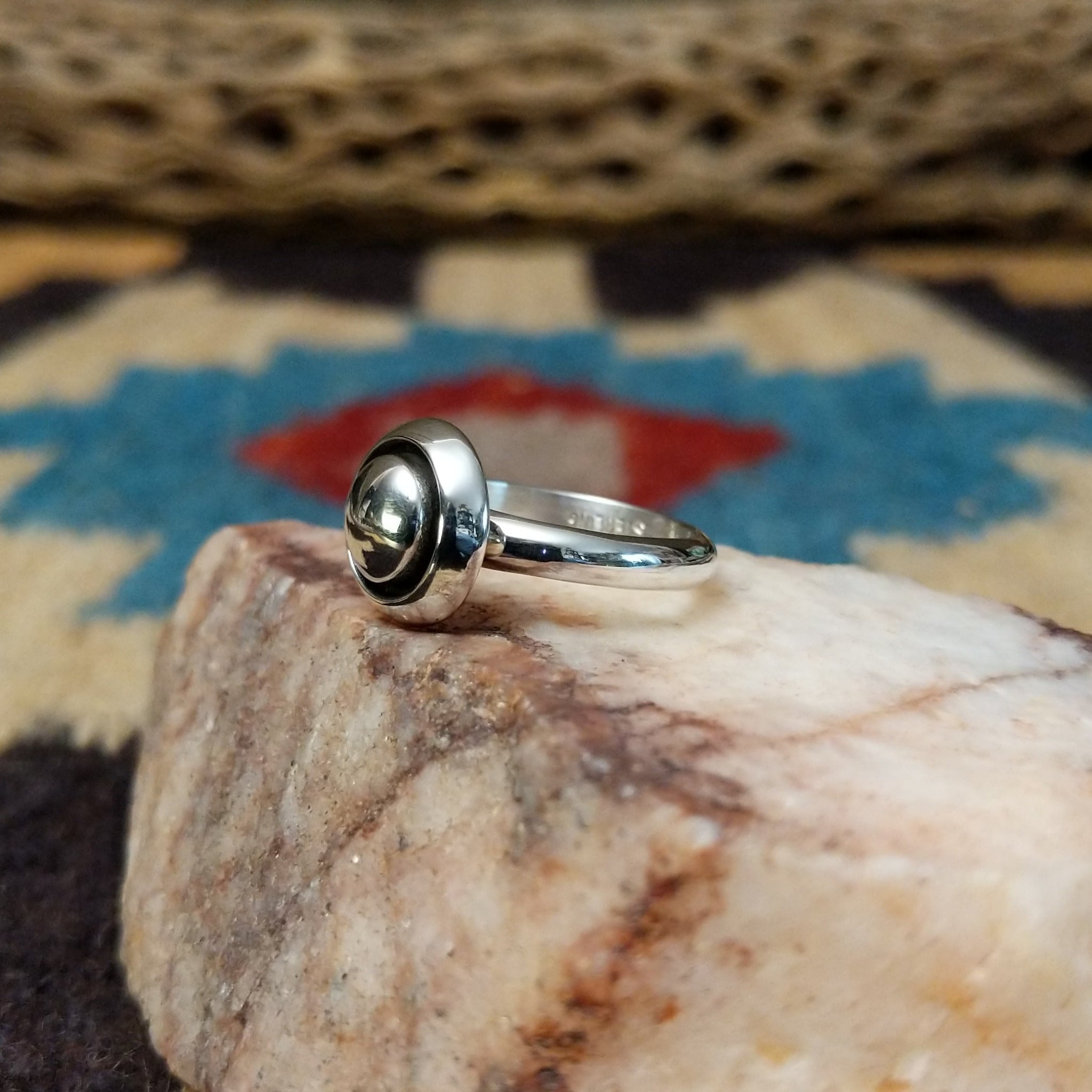 Silver dome shadowbox ring by Tricia Smith, featuring a handcrafted sterling silver dome with a dimensional shadowbox design and polished finish. Side view.