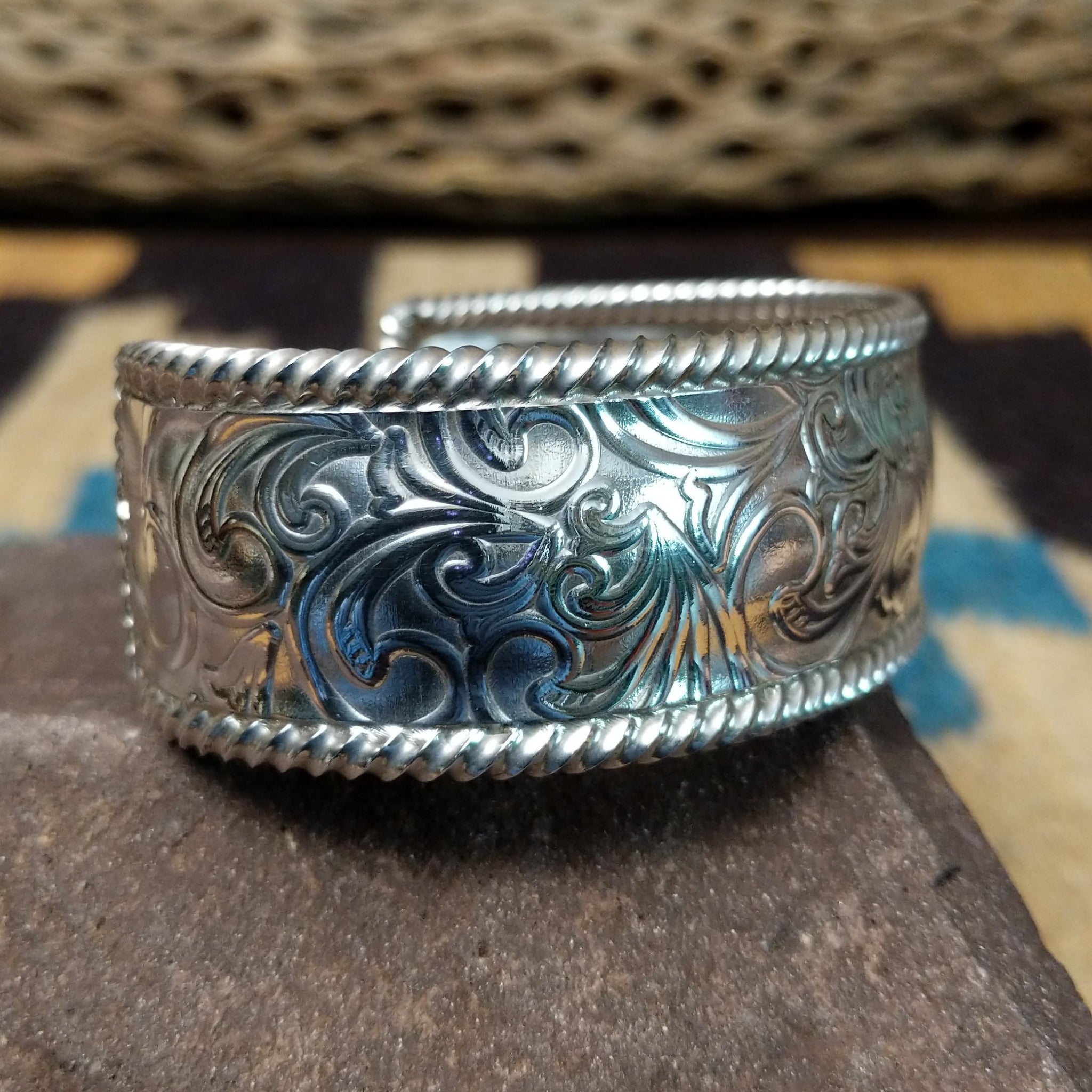 Silver filigree cuff by Larry Joe, featuring hand-engraved scrollwork framed by twisted rope borders on a handcrafted wide sterling silver open cuff.