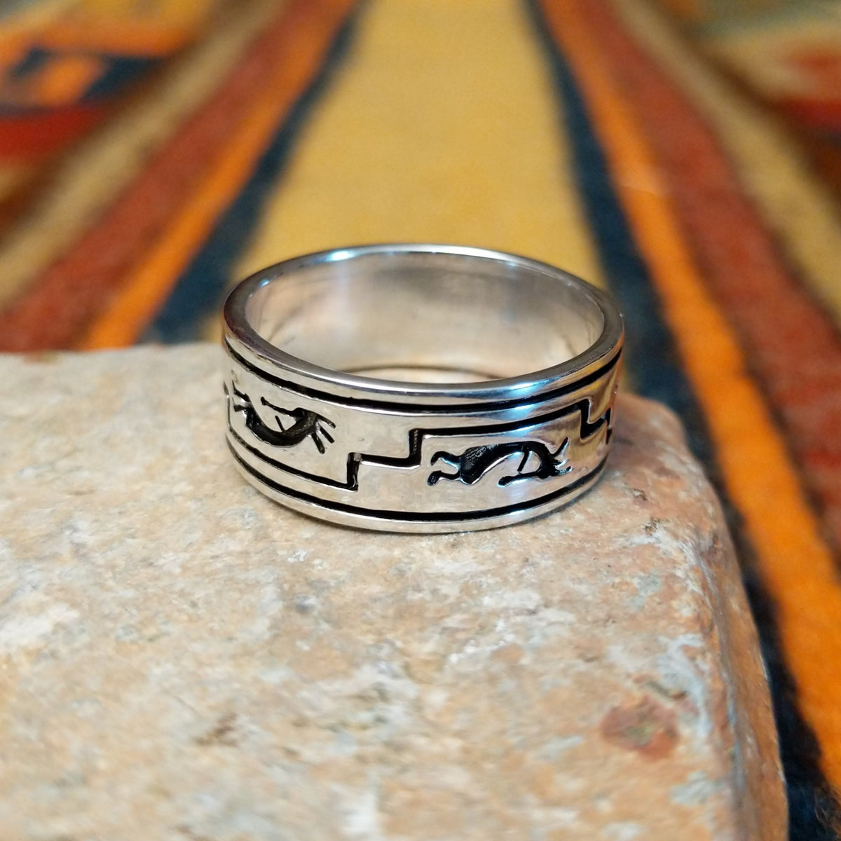 Silver Kokopelli Ring by Irene Kee featuring a wide polished silver band with a flute-playing Kokopelli figure, geometric Southwestern patterns, oxidized detailing, and smooth silver edges.