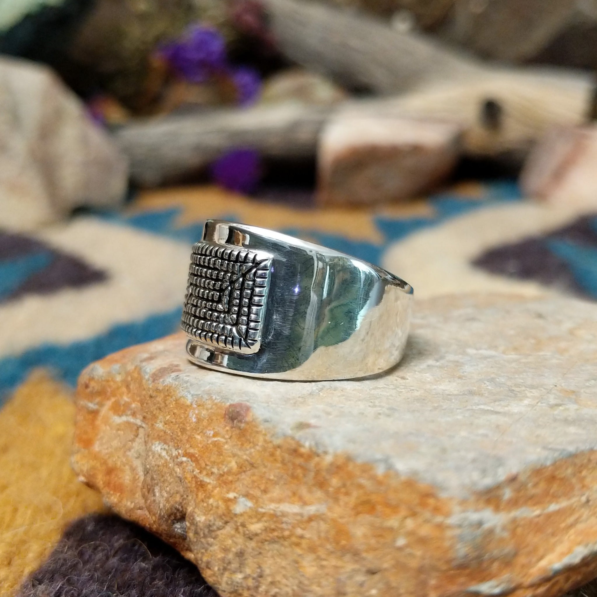 Sterling silver ring by Raymond Coriz with a rectangular hand-stamped geometric design; side view.