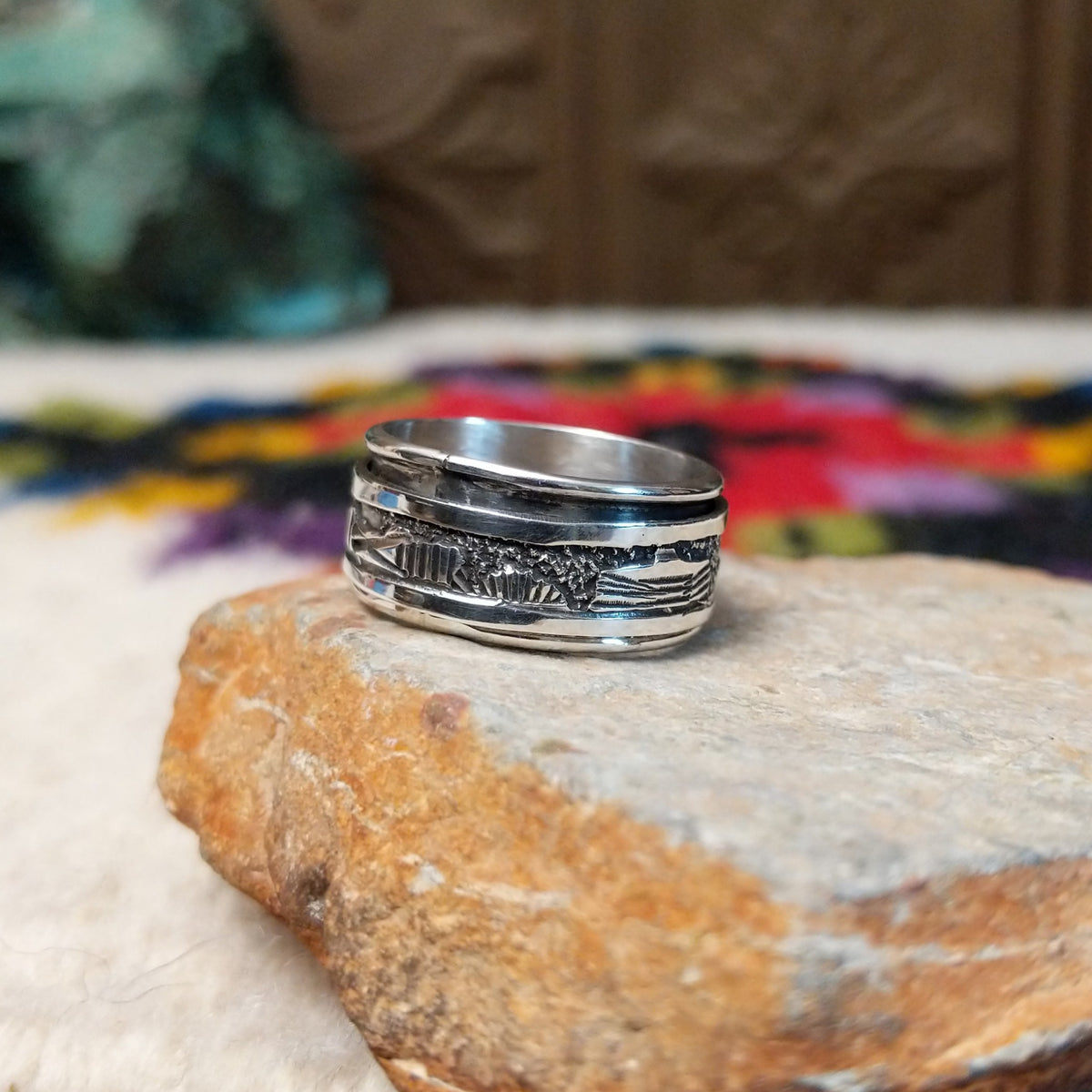 Silver spinner ring by Elaine Becenti with stamped geometric designs and layered movable bands.