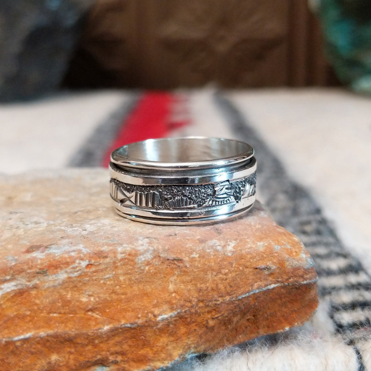 Silver spinner ring by Elaine Becenti with stamped rotating outer band.