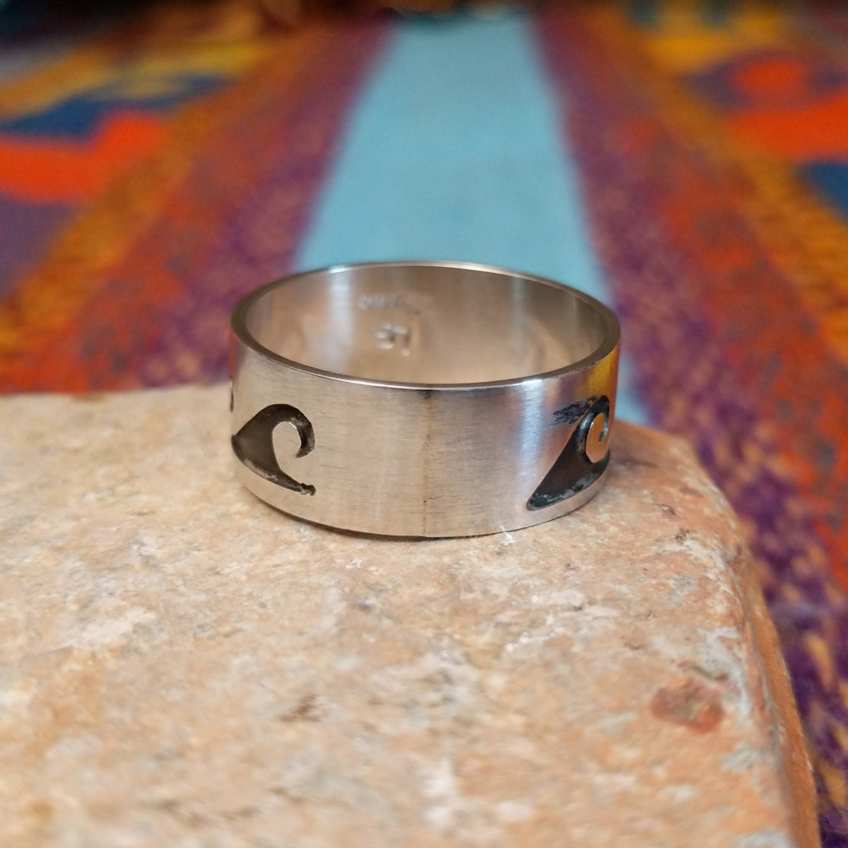 Silver Wave Ring by Lester Gene featuring a wide brushed silver band with a repeating oxidized wave pattern and polished lower border; underside view.