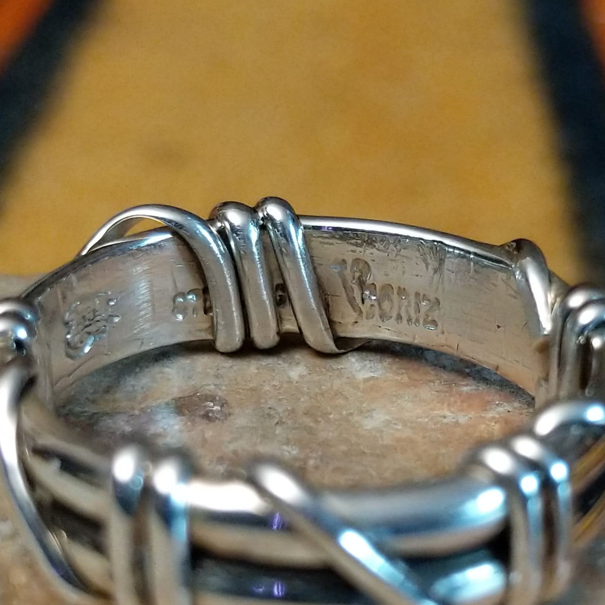 Silver Wire Ring by Raymond Coriz featuring layered sterling silver bands with curved wire wraps, decorative coils, and a polished finish in a Native American Southwestern design; artisan and Sterling Silver stamp.