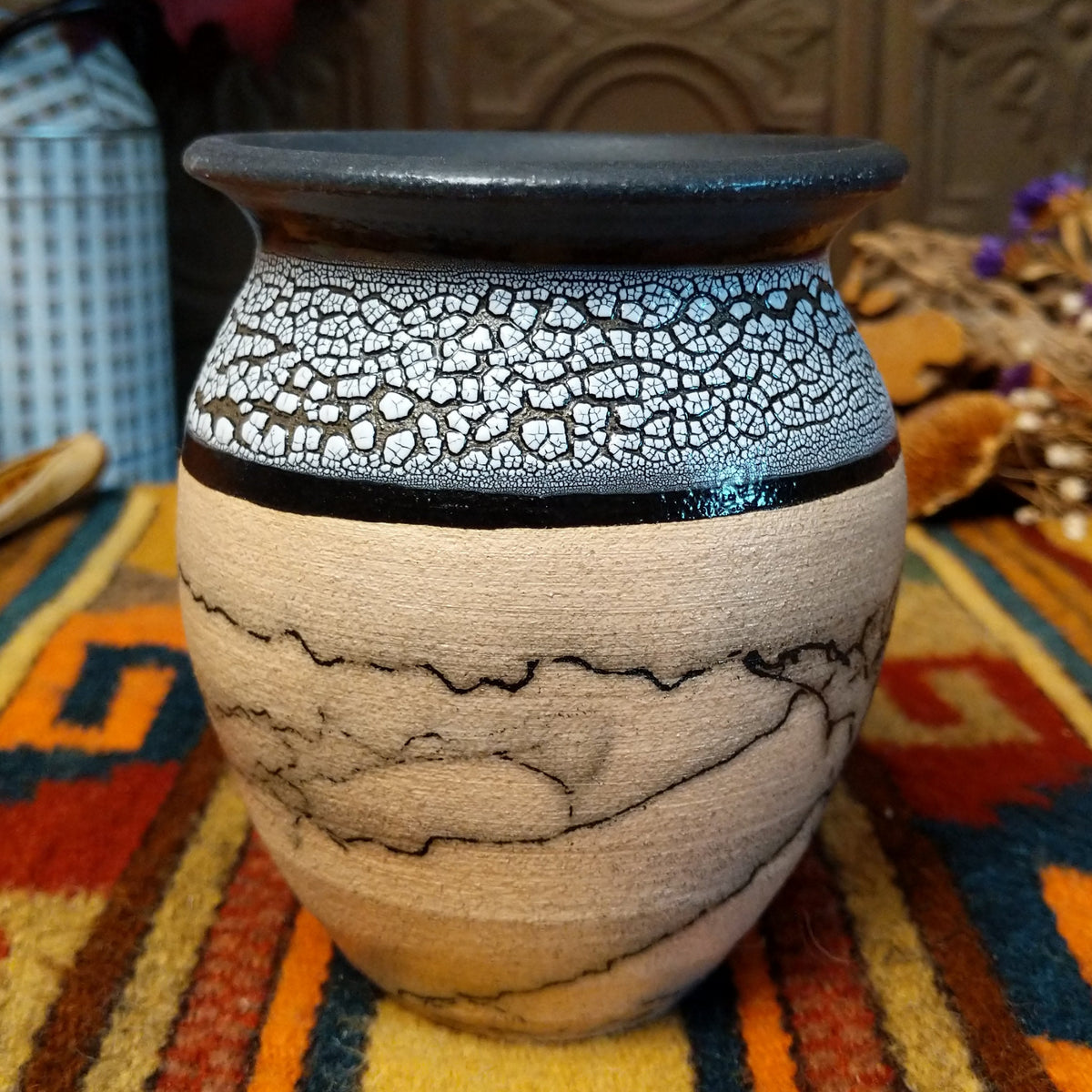 This distinctive Small Horsehair Pottery by Roger Calhoun features a tapered ceramic vessel with natural earth tones, black horsehair patterns, a decorative black-and-white crackled upper section, and a wide black rim.