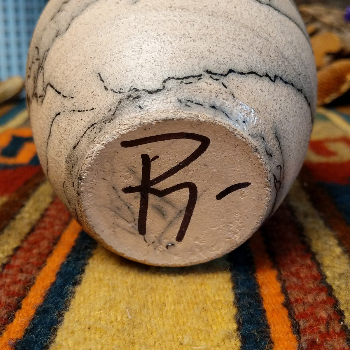 This distinctive Small Horsehair Pottery by Roger Calhoun features a tapered ceramic vessel with natural earth tones, black horsehair patterns, a decorative black-and-white crackled upper section, and a wide black rim; underside and artisan signature view.