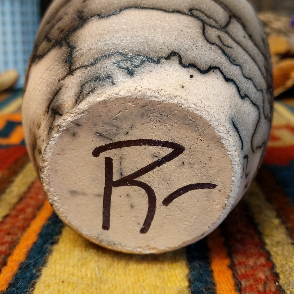 This distinctive Small Horsehair Pottery by Roger Calhoun features a tapered ceramic vessel with natural earth tones, black horsehair patterns, a decorative black-and-white crackled upper section, and a wide black rim; underside view with artisan signature.