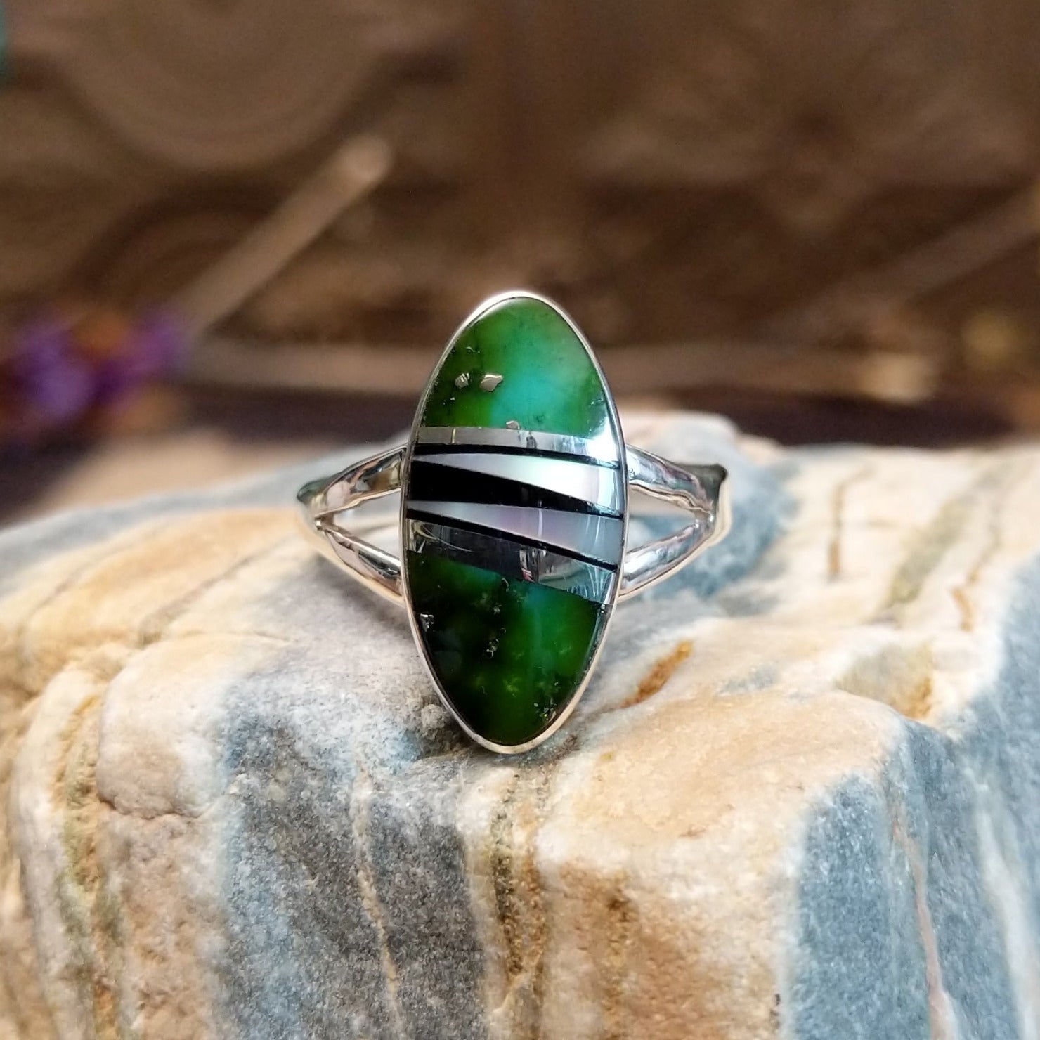 Sterling silver ring with multistone inlay set in an oval bezel.