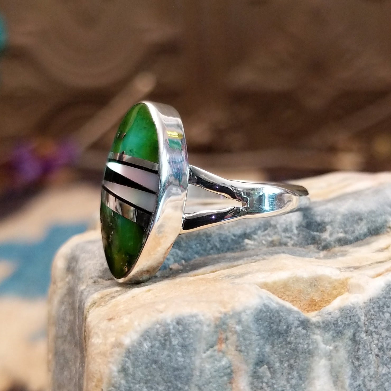 Sterling silver ring with multistone inlay set in an oval bezel.