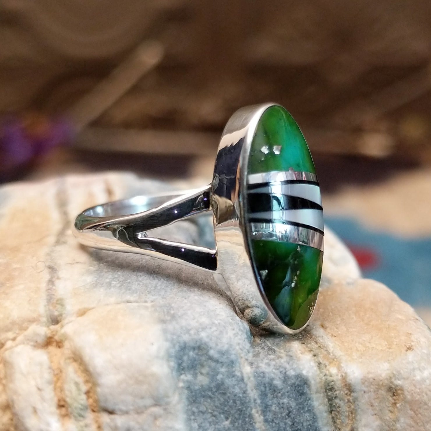 Sterling silver ring with multistone inlay set in an oval bezel.