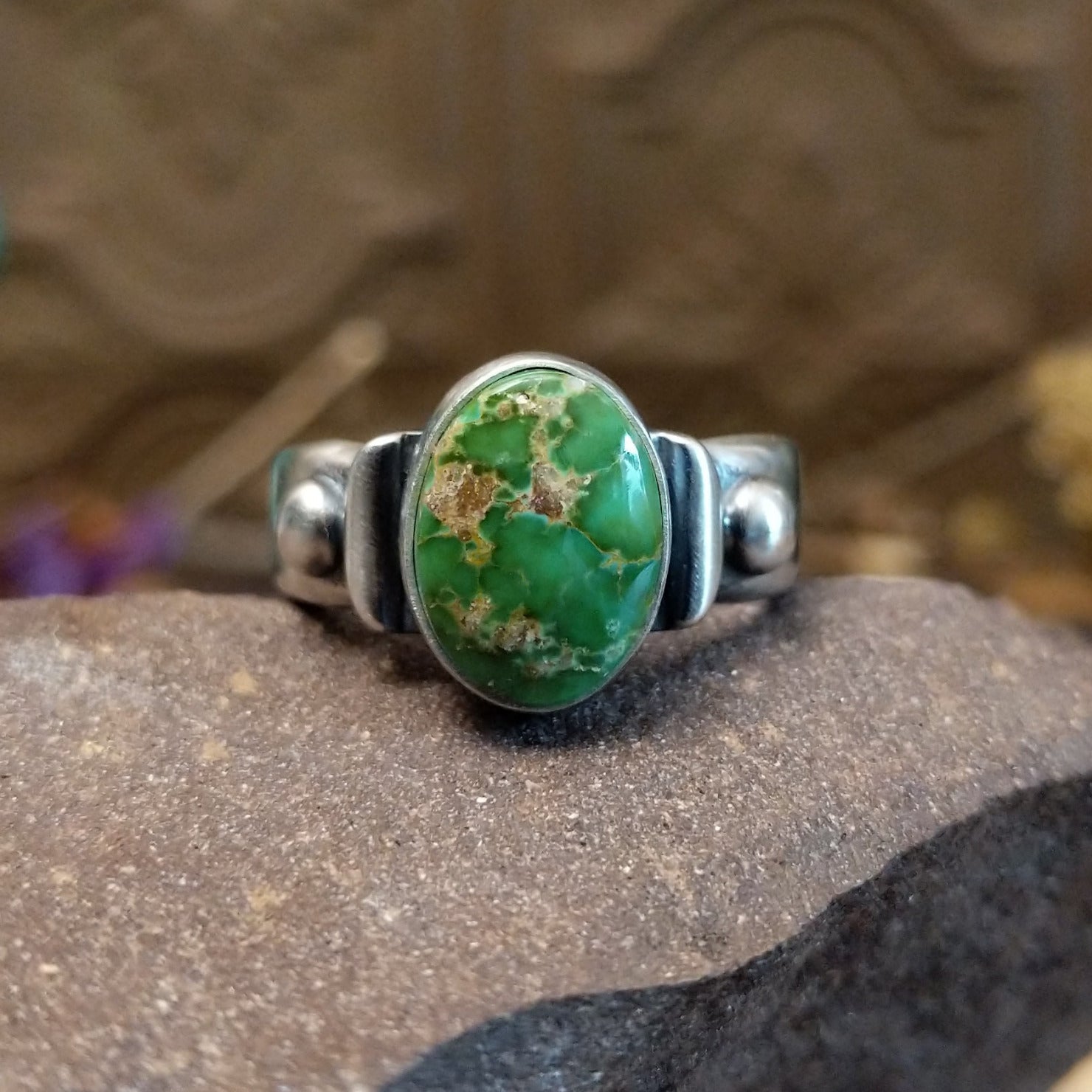 Sterling silver ring with Sonoran gold turquoise set in a raised, oval bezel and brushed finish.