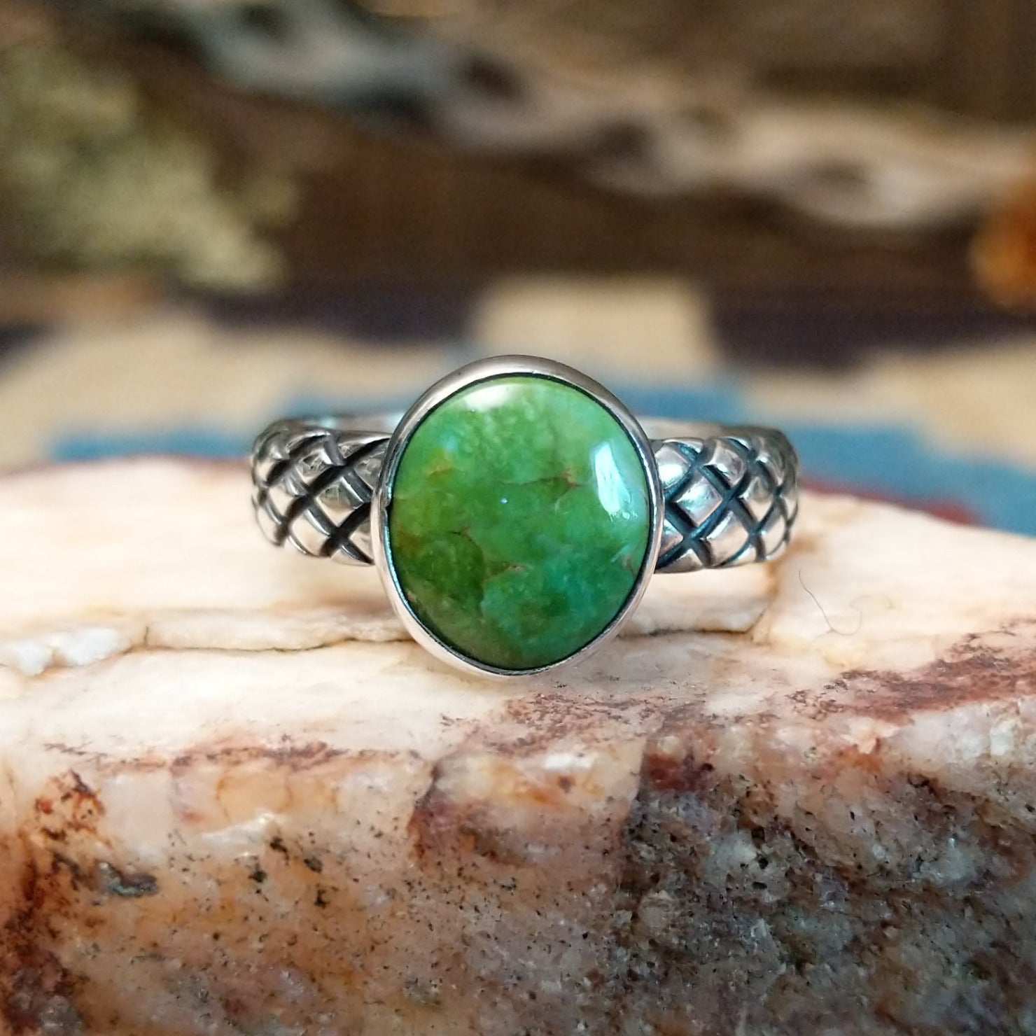 Sterling silver ring with Sonoran gold turquoise set in a round bezel and basket stamps along the band.