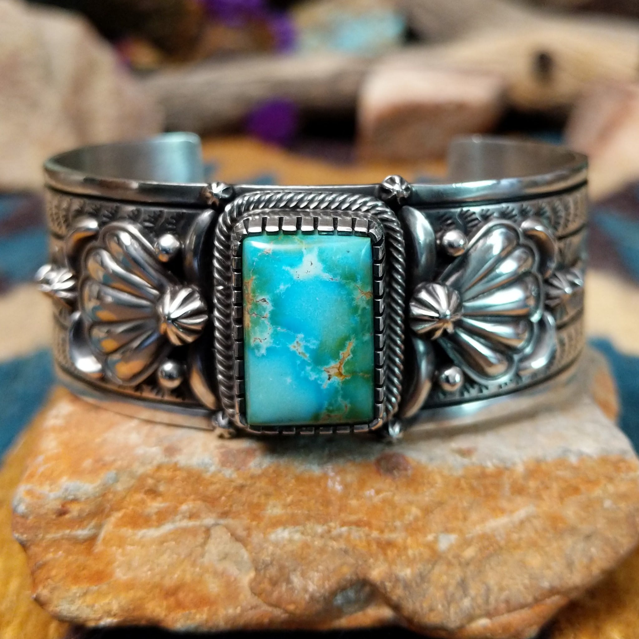 Handcrafted Navajo sterling silver cuff by Murphy Platero featuring a rectangular Sonoran Mountain turquoise cabochon with a twisted rope bezel, repoussé conchos, hand-stamped details, and polished silver accents.