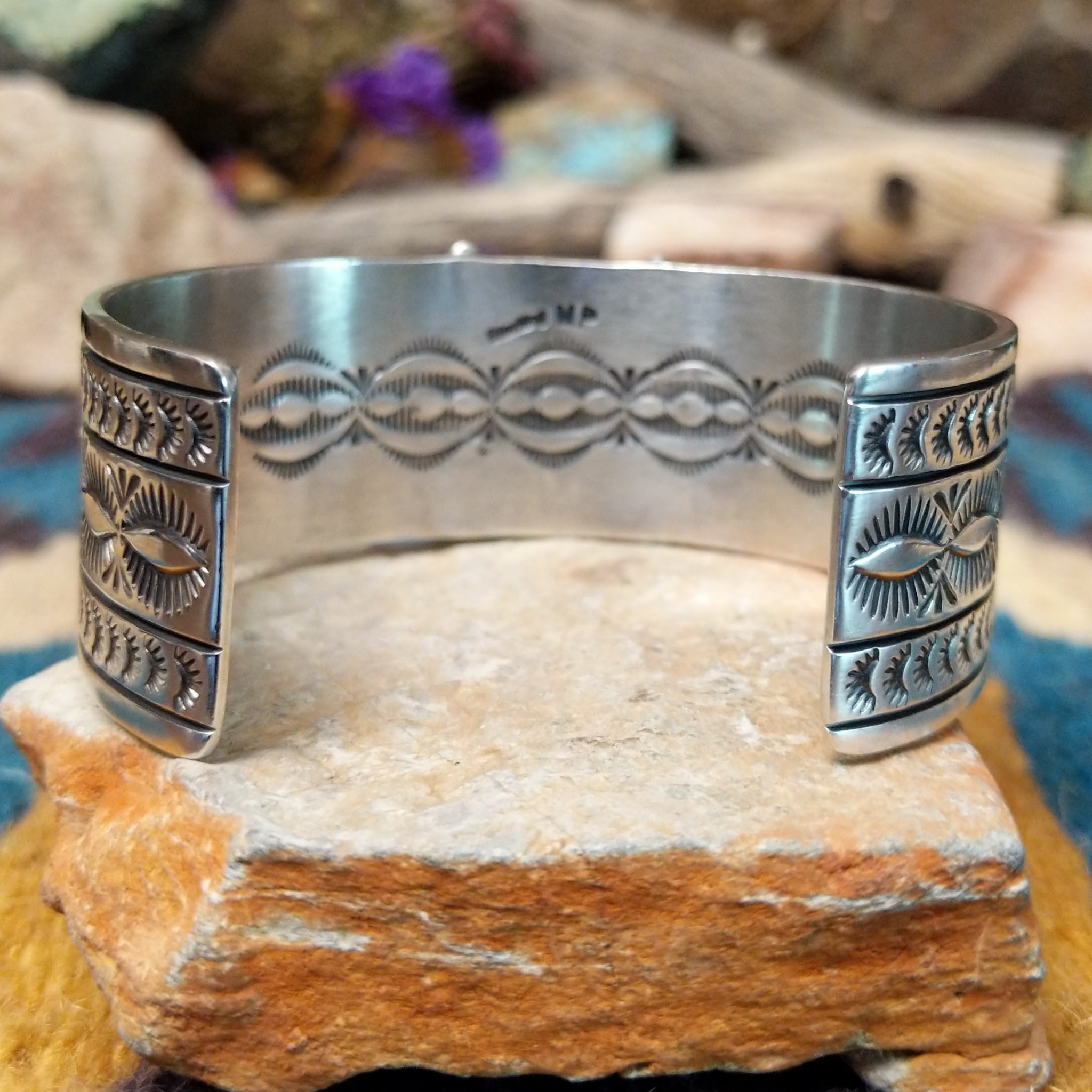 Handcrafted Navajo sterling silver cuff by Murphy Platero featuring a rectangular Sonoran Mountain turquoise cabochon with a twisted rope bezel, repoussé conchos, hand-stamped details, and polished silver accents; underside view.