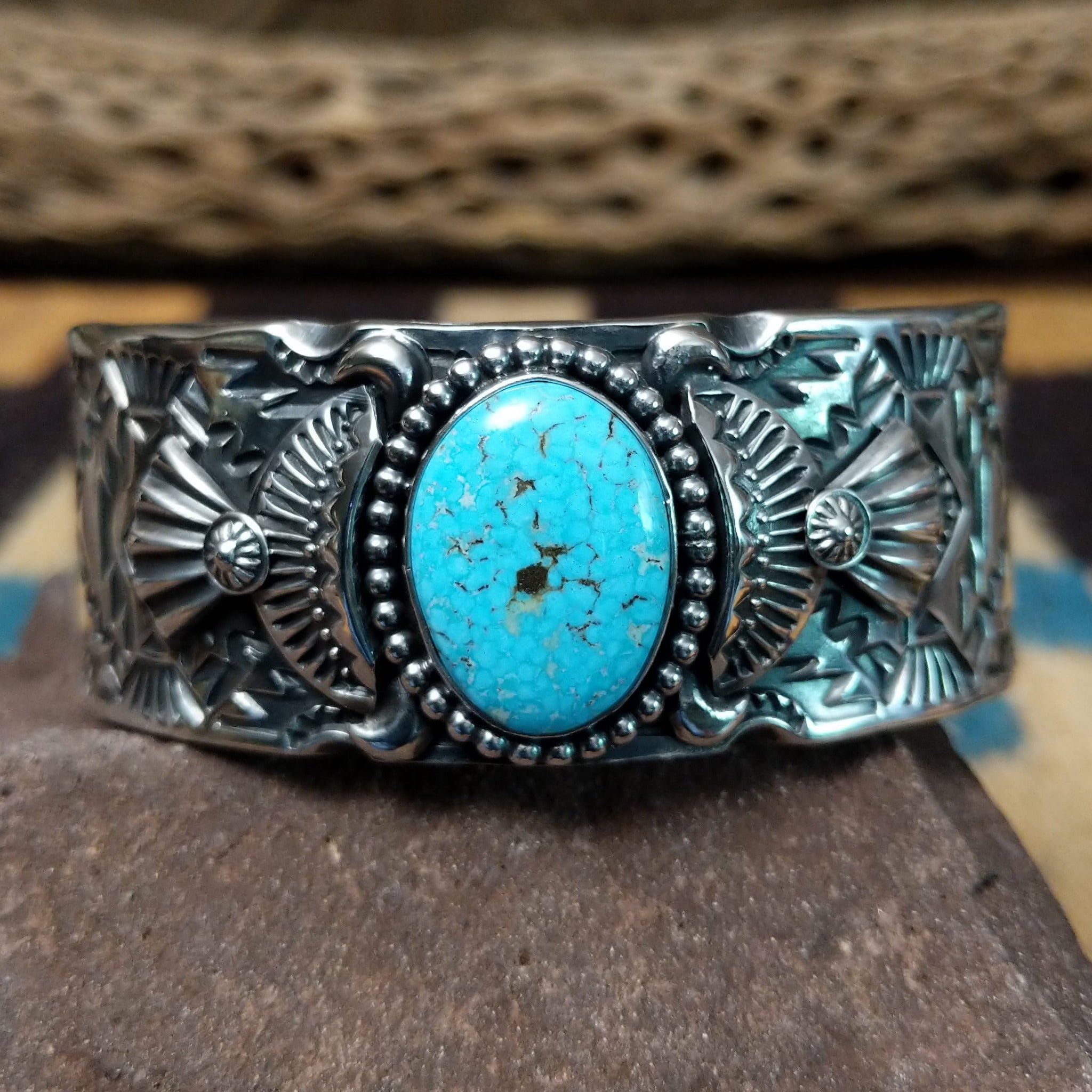 Spiderweb #8 turquoise cuff by Andrew Gordon, featuring an oval blue Spiderweb #8 turquoise stone with natural spiderweb matrix set in a handcrafted sterling silver cuff with hand-stamped fan and geometric designs.