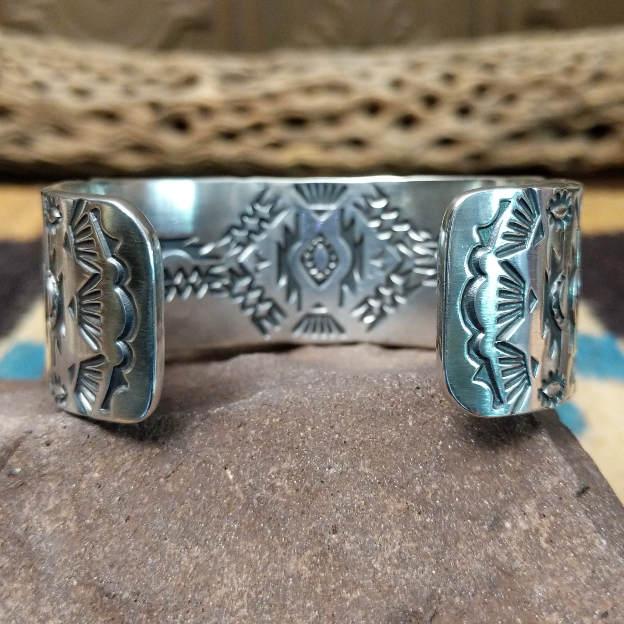 Spiderweb #8 turquoise cuff by Andrew Gordon, featuring an oval blue Spiderweb #8 turquoise stone with natural spiderweb matrix set in a handcrafted sterling silver cuff with hand-stamped fan and geometric designs; underside view.