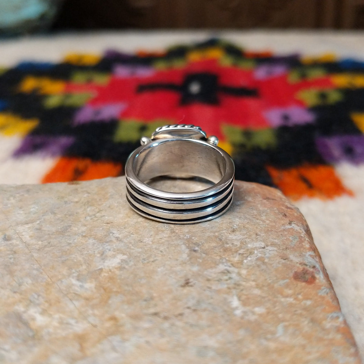 This Square Lapis Ring by Raymond Coriz features a square blue lapis stone set in sterling silver with a twisted rope border, silver bead accents, and a multi-band design; underside view.