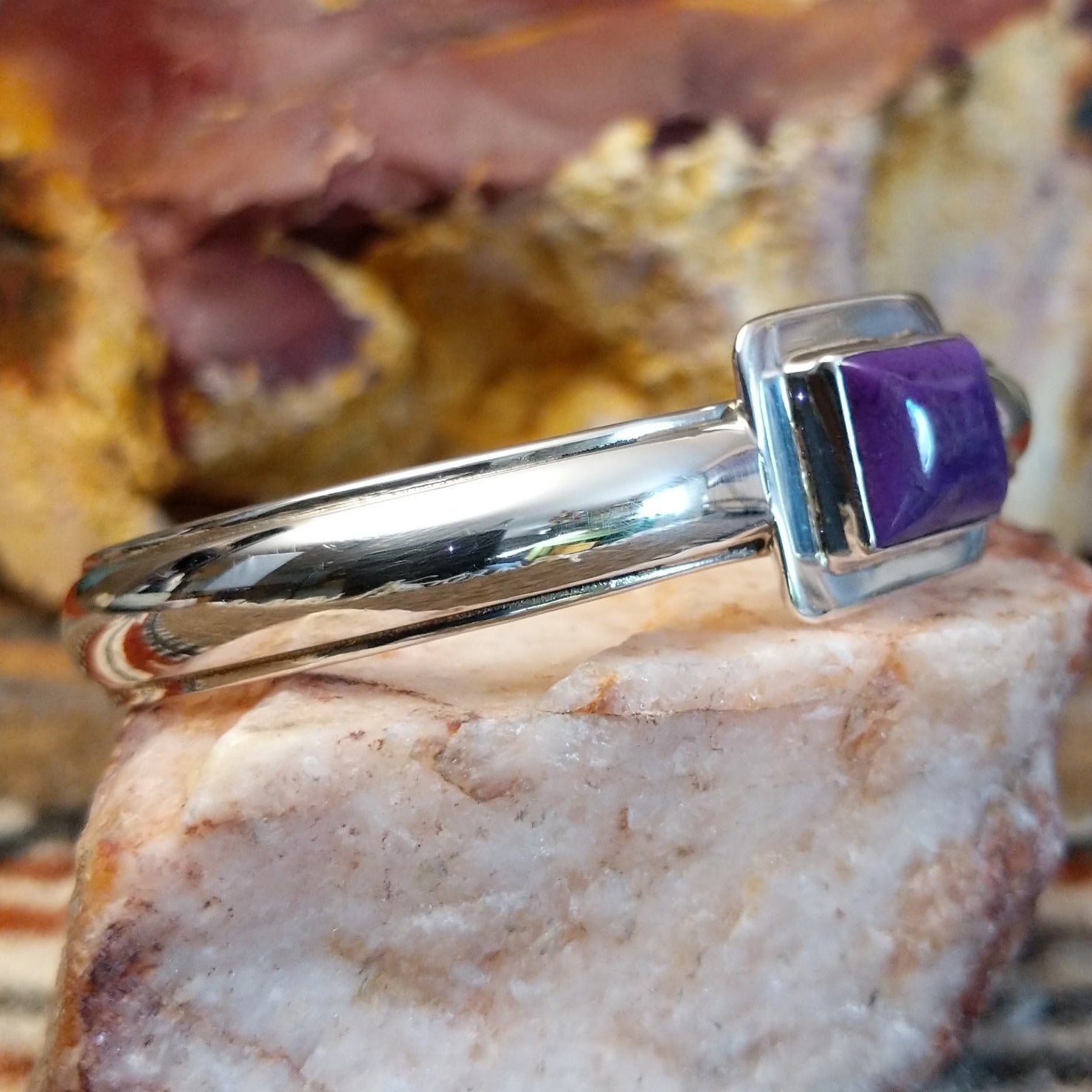 Sugilite set within the square bezel of of the polished silver cuff.