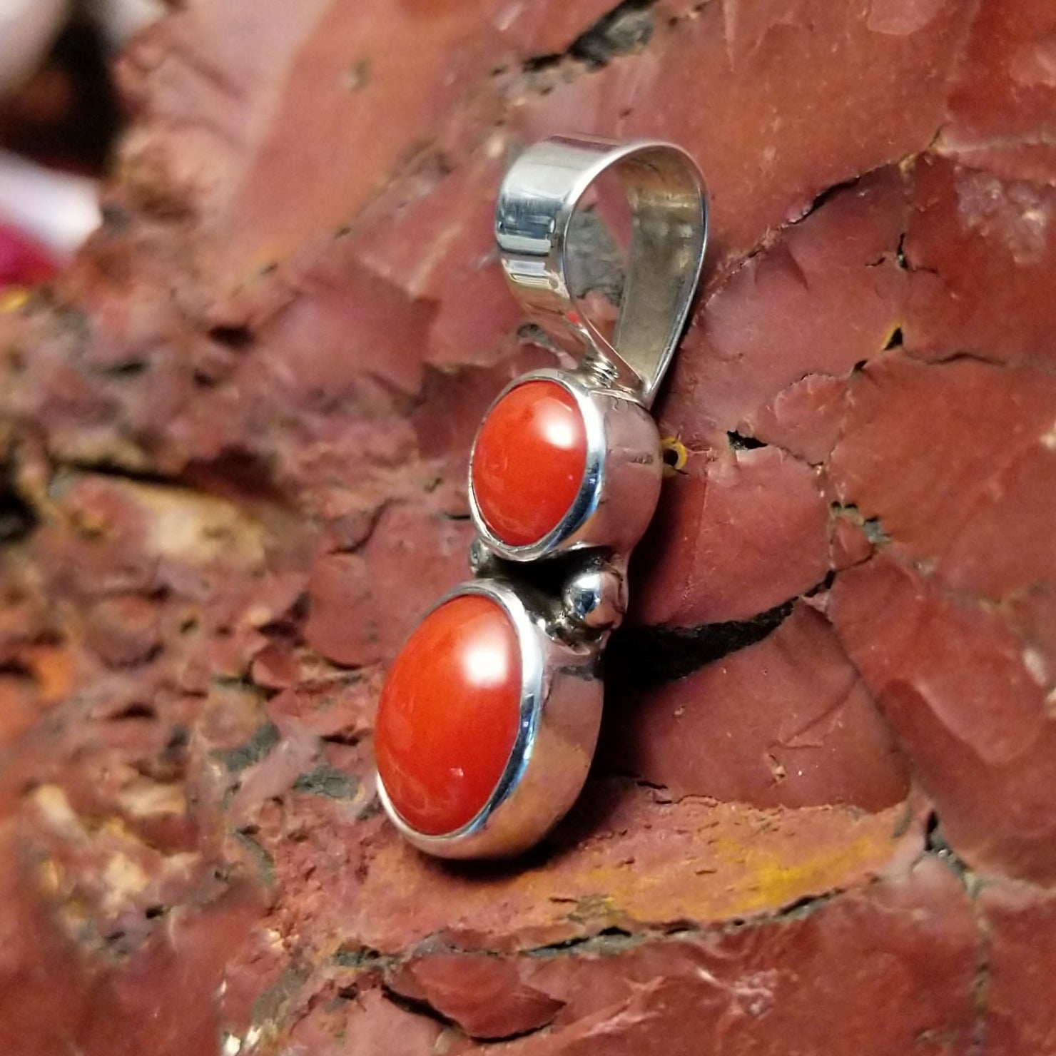 Sterling silver pendant with coral set in the two bezels.