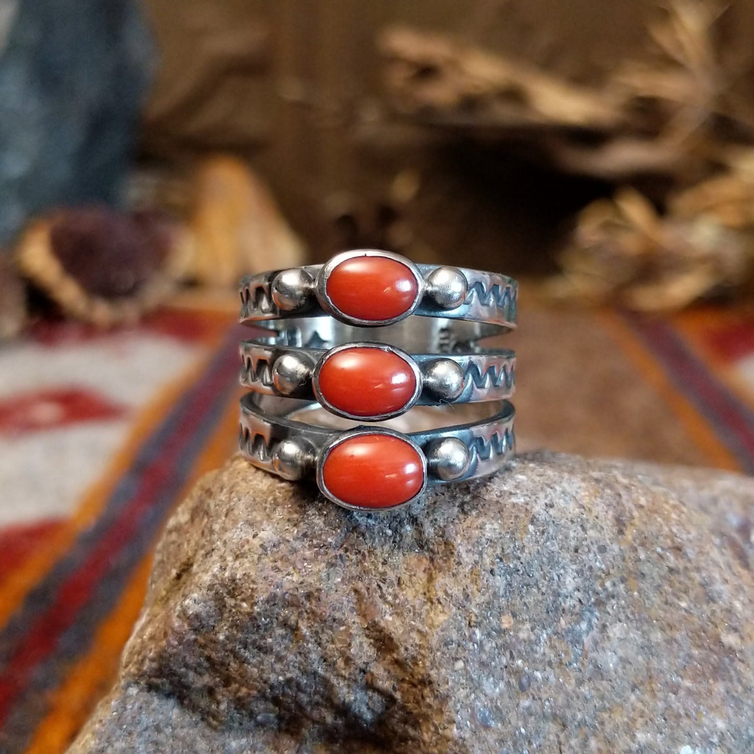 Stacked sterling silver ring with coral set in three oval bezels and stamping on the bands.